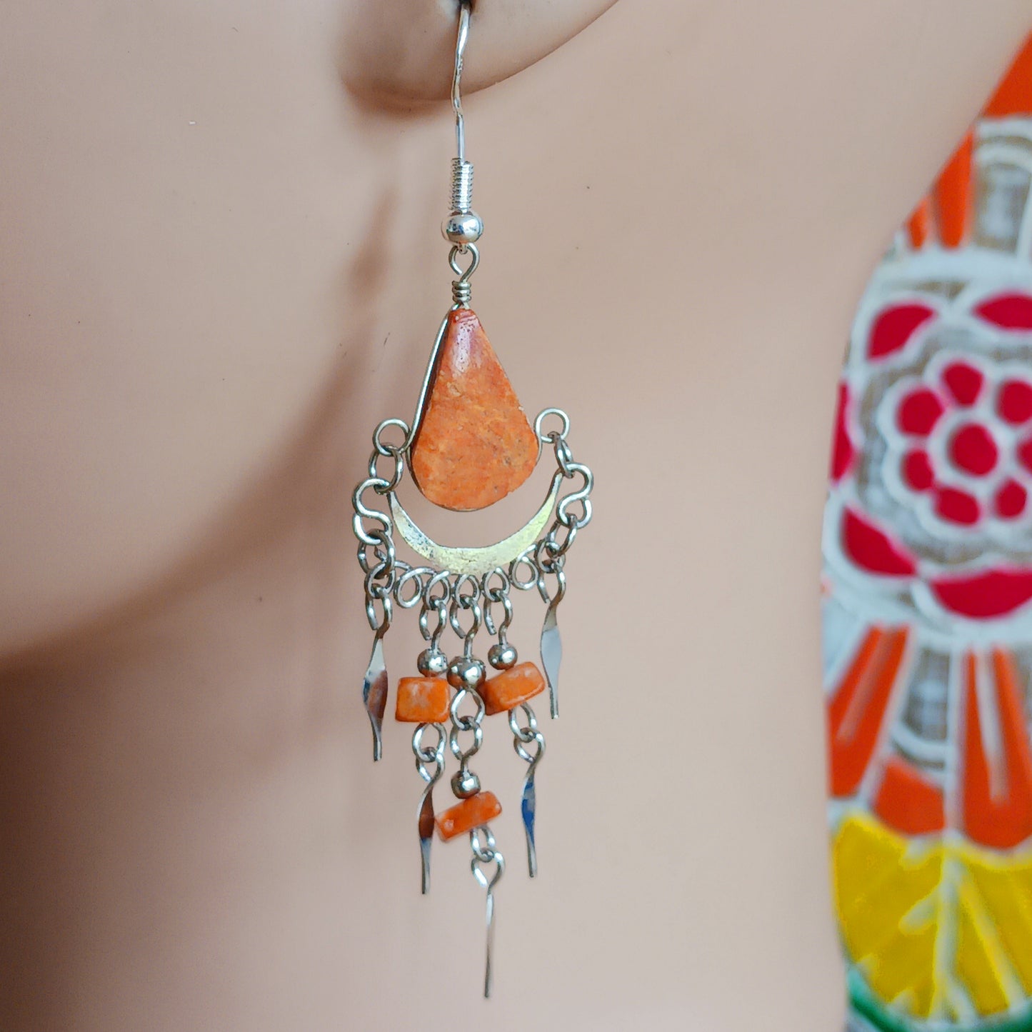 Add a touch of bohemian beauty to your look with these handmade Peruvian stone earrings. Featuring orange stones and finished with silver-plated hooks, each pair is carefully crafted in small workshops in Peru.