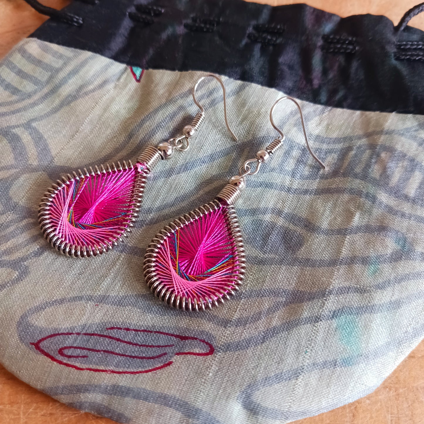 Add a touch of effortless boho elegance to your look with these beautifully handmade woven teardrop earrings. Inspired by the graceful shape of peacock feathers, these lightweight dangly earrings are expertly crafted by skilled artisans in Peru using traditional weaving techniques and vibrant contemporary detailing.