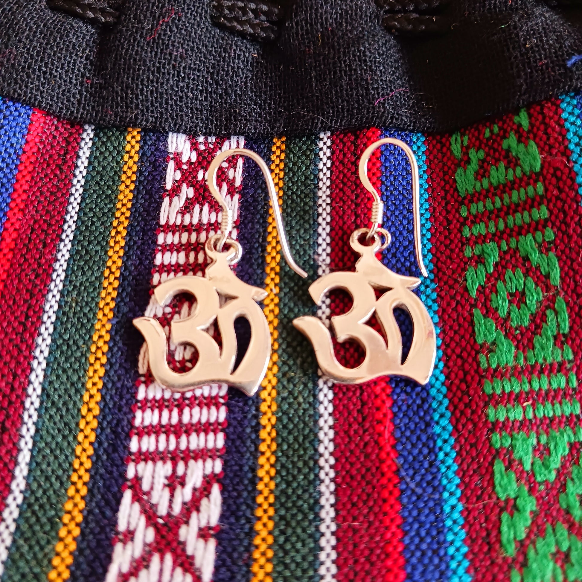Experience spiritual harmony and elevate your style with these Sterling Silver Om dangle earrings. 