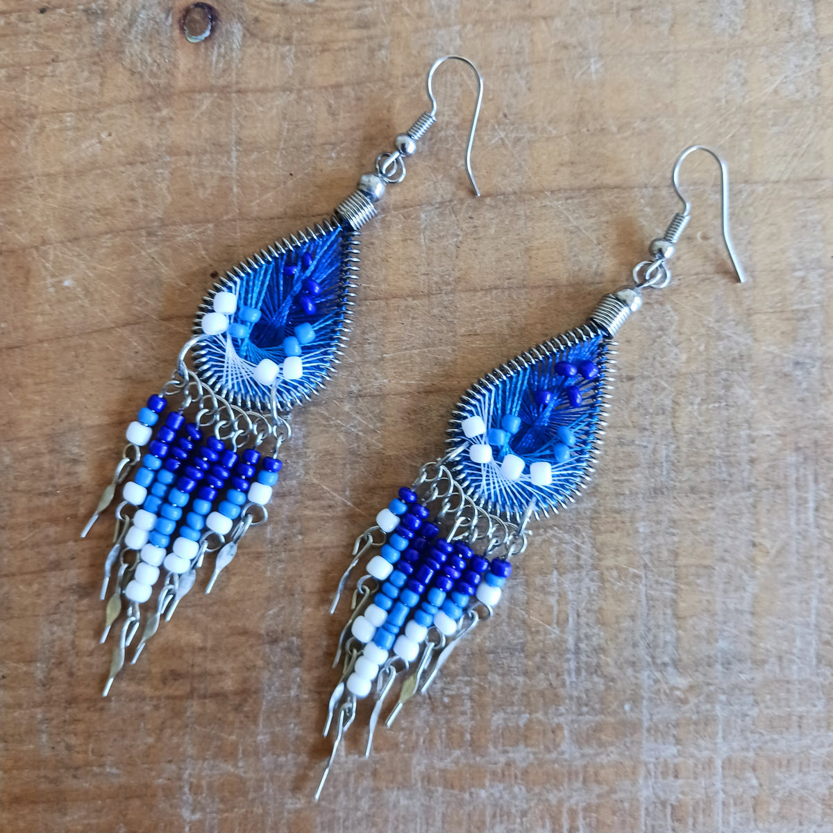 Add a splash of colour to your look with these beautiful handmade Peruvian woven teardrop earrings. Inspired by the vibrant colours and patterns of a peacock feather, each earring features intricate woven detailing complemented by coordinating beads and delicate silver-tone embellishments.
