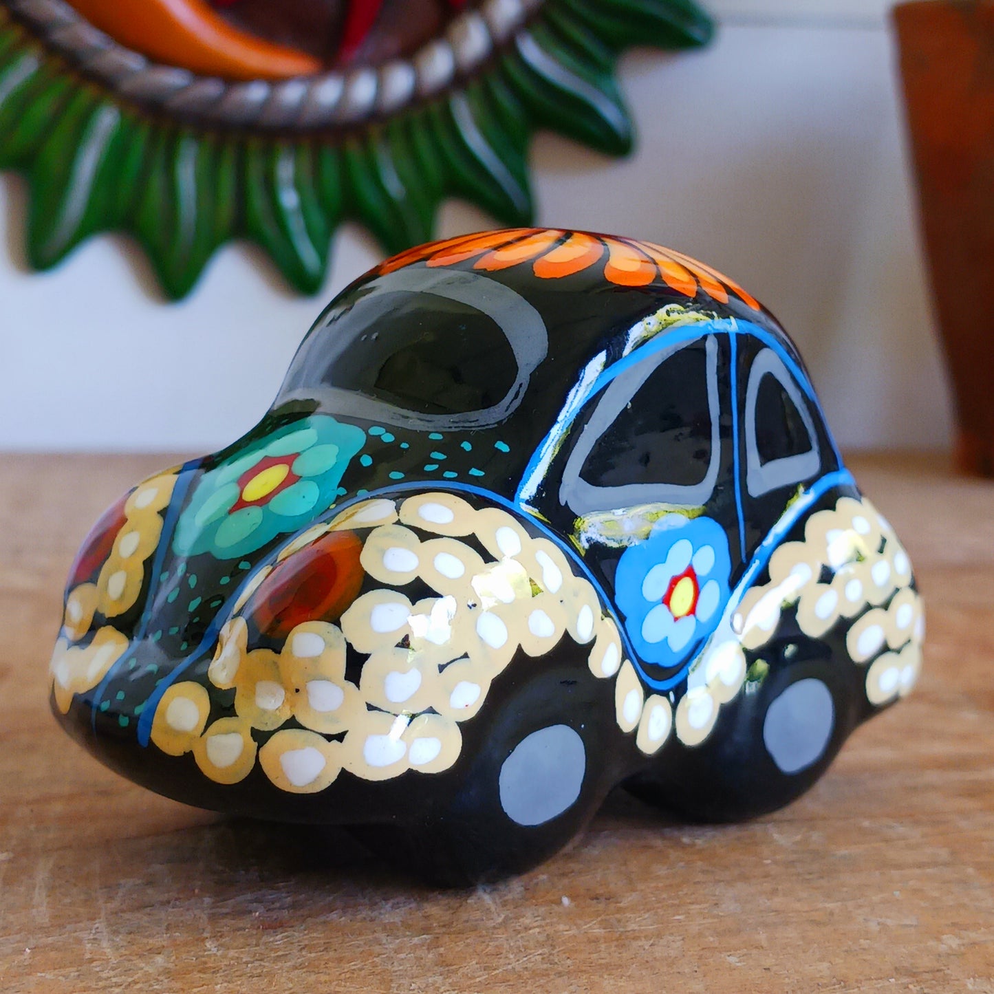 This fun little VW car ornament oozes retro vibes.  With it's bold flower power design and vibrant colours it will brighten up any sideboard.  This type of car, affectionately known as a 'bochito', are very popular in Mexico due to their reliability when driving about steep roads. Incidentally, the Mexican town of Puebla was home to the last Beetle production factory which only closed in 2003.