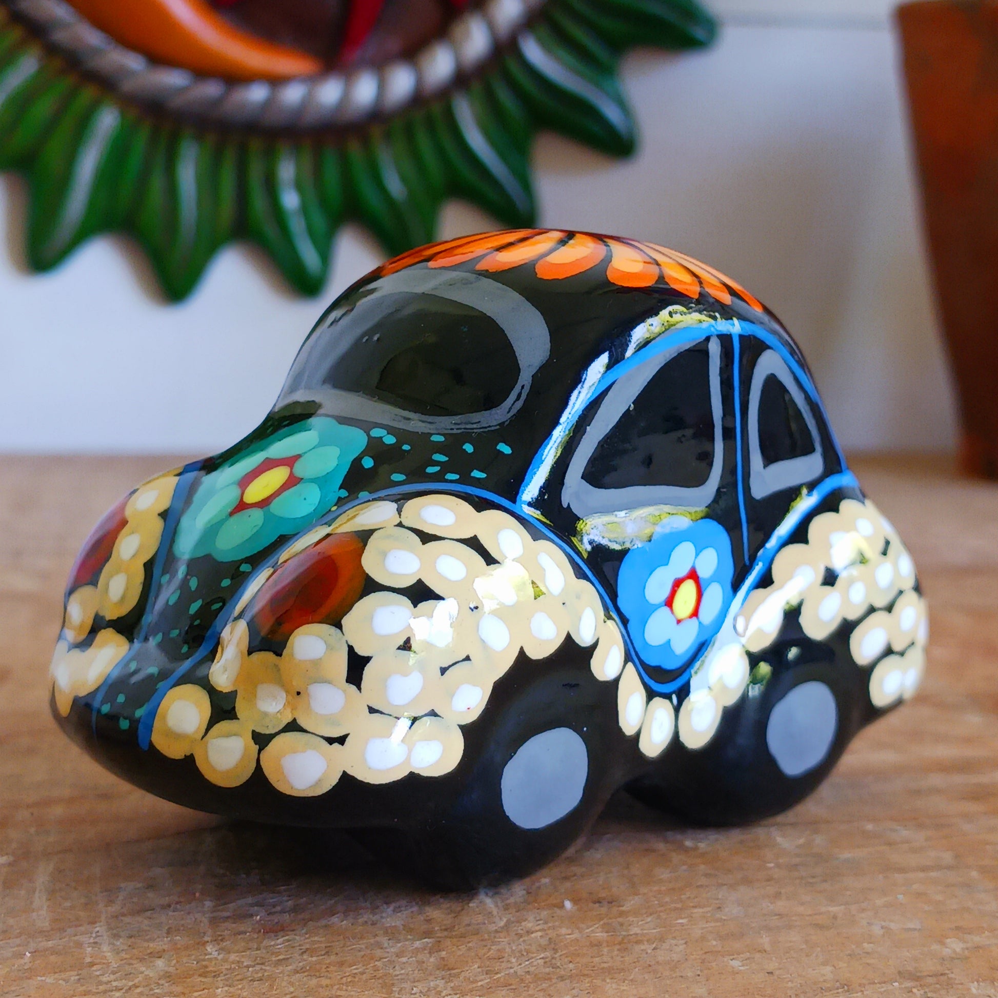 This fun little VW car ornament oozes retro vibes.  With it's bold flower power design and vibrant colours it will brighten up any sideboard.  This type of car, affectionately known as a 'bochito', are very popular in Mexico due to their reliability when driving about steep roads. Incidentally, the Mexican town of Puebla was home to the last Beetle production factory which only closed in 2003.