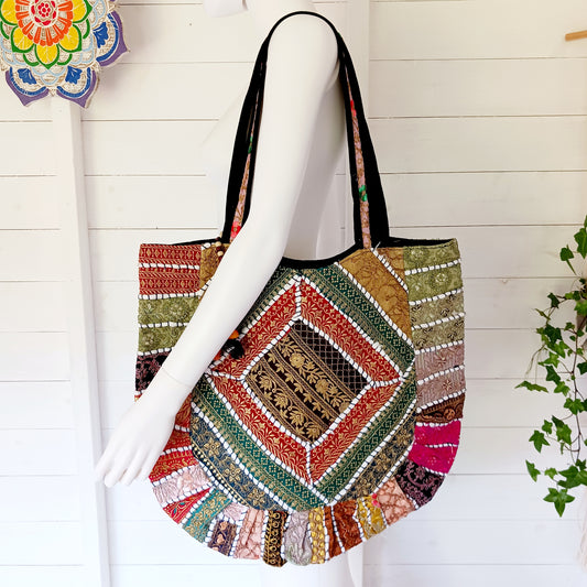 This beautiful large Indian tote bag comes with a wide shoulder strap and plenty of space inside for your personal items. In a patchwork style design, this bag is intricately embroidered with a traditional bohemian pattern. The bag comes decorated with beads and pom poms and is fully lined throughout.
