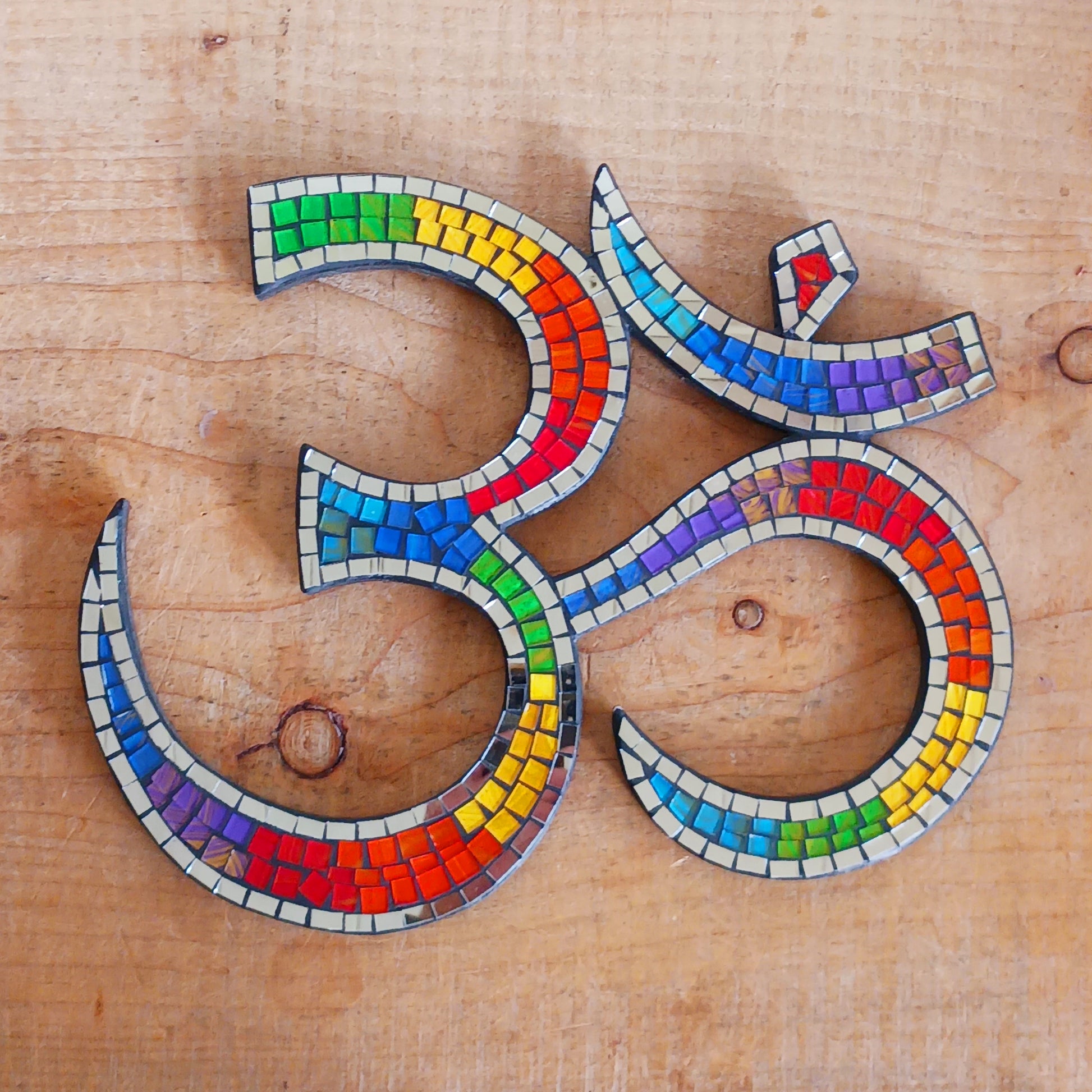 Bring serenity and colour into your sacred space with our&nbsp;Rainbow Mosaic Om Wall Plaque. This stunning piece features a vibrant rainbow design representing the powerful Om symbol — a timeless emblem of inner peace, spiritual connection, and mindfulness. Perfect for meditation rooms, yoga studios, or as a thoughtful gift, this plaque adds both beauty and positive energy to any home décor.