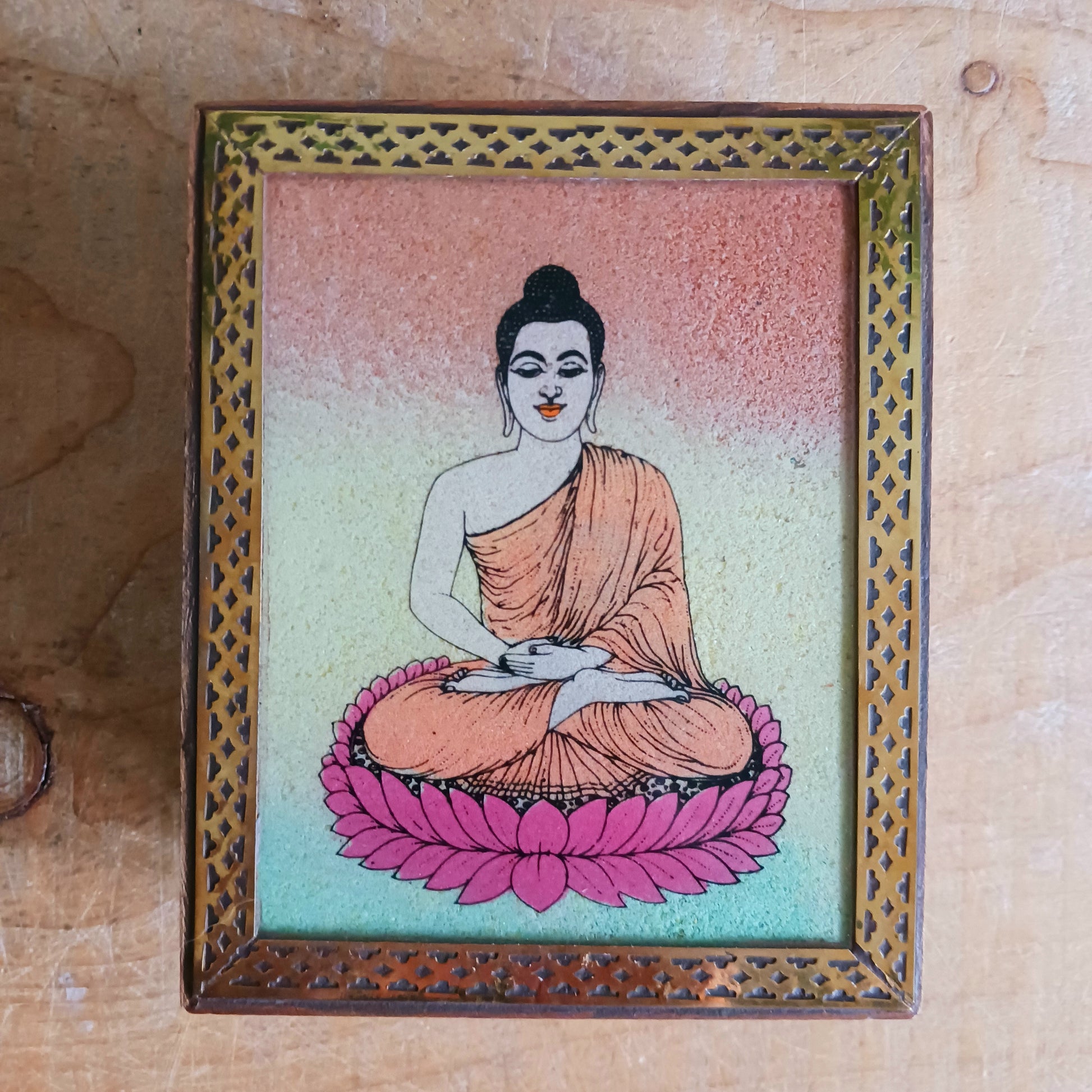 Bring peace and elegance to your space with this exquisite decorative mango wood box. Featuring a vibrant sand painting of Buddha in the meditation mudra, this piece is a true work of art. The detailed image is first hand-painted on a glass top and then filled with colourful sand, giving it depth and texture.