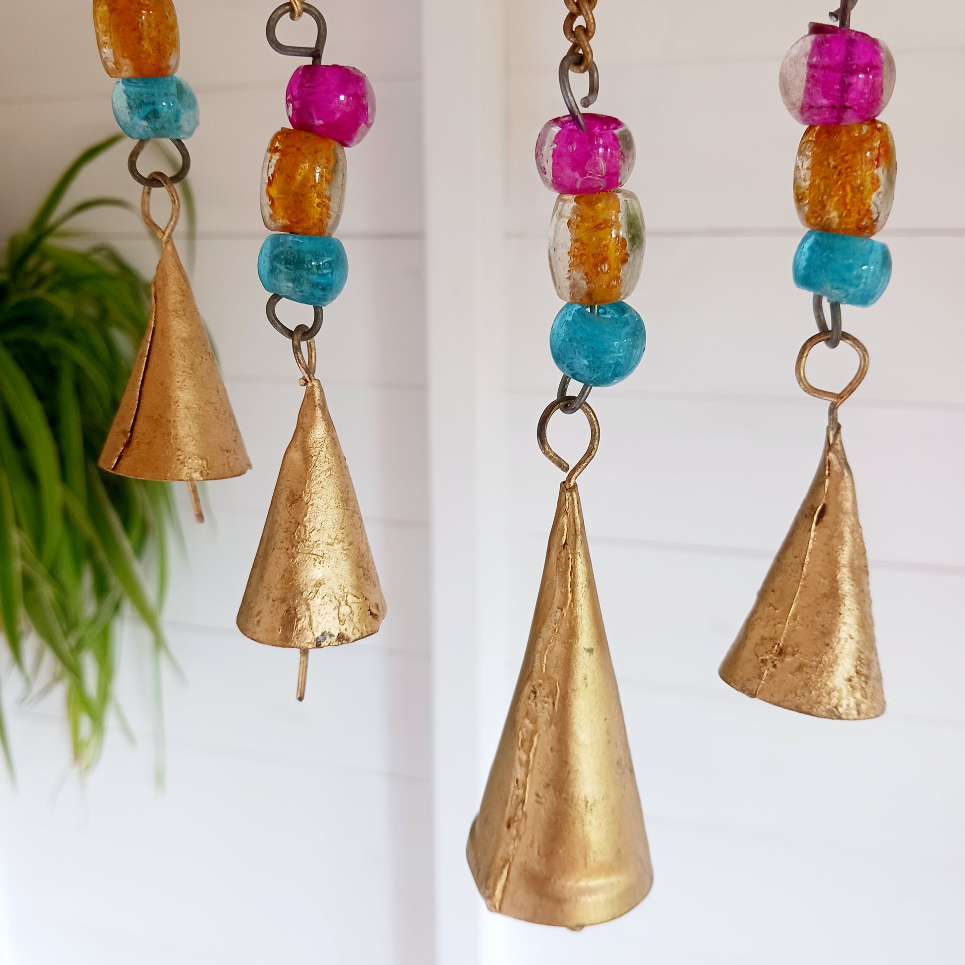 This lovely Buddha 5 bell windchime will bring serenity and cultural charm to any space.  Made in India from brass, this chime features a beautifully detailed Buddha adorned with colourful beads. 
 The five brass bells create a calming melody with every breeze, making it a perfect addition to meditation spaces, gardens, or tranquil home settings.