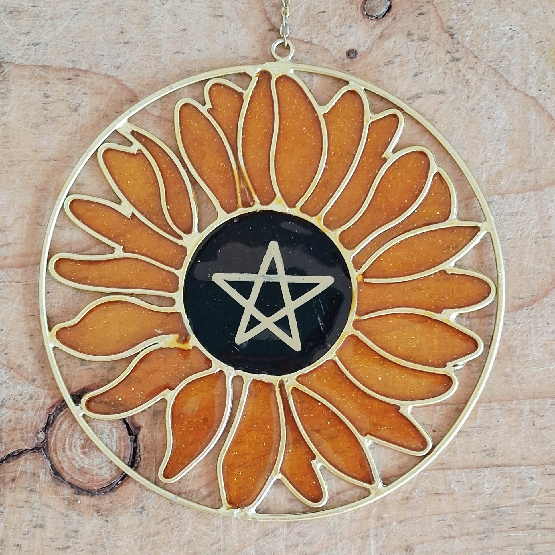 Add a touch of sunshine to the home with this Summer Solstice sunflower suncatcher. This charming suncatcher is inspired by the Summer Solstice, featuring a beautifully detailed sunflower, pentagram, star and crescent moon design made from metal and resin. Hang it in the window to catch the light and bring a cheerful, colourful glow to any room.