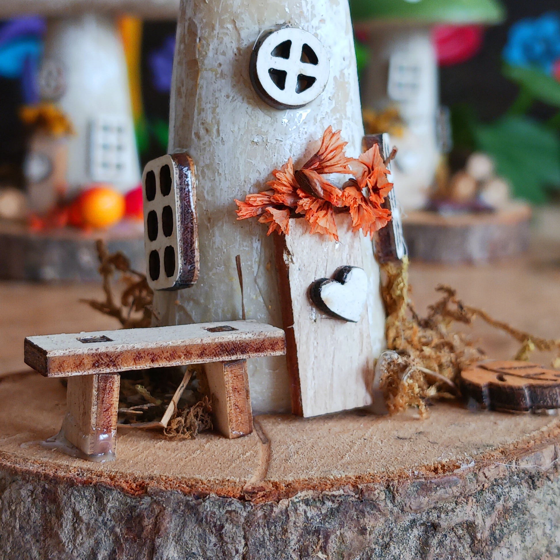 Small wooden fairy house with a bench on a tree stump