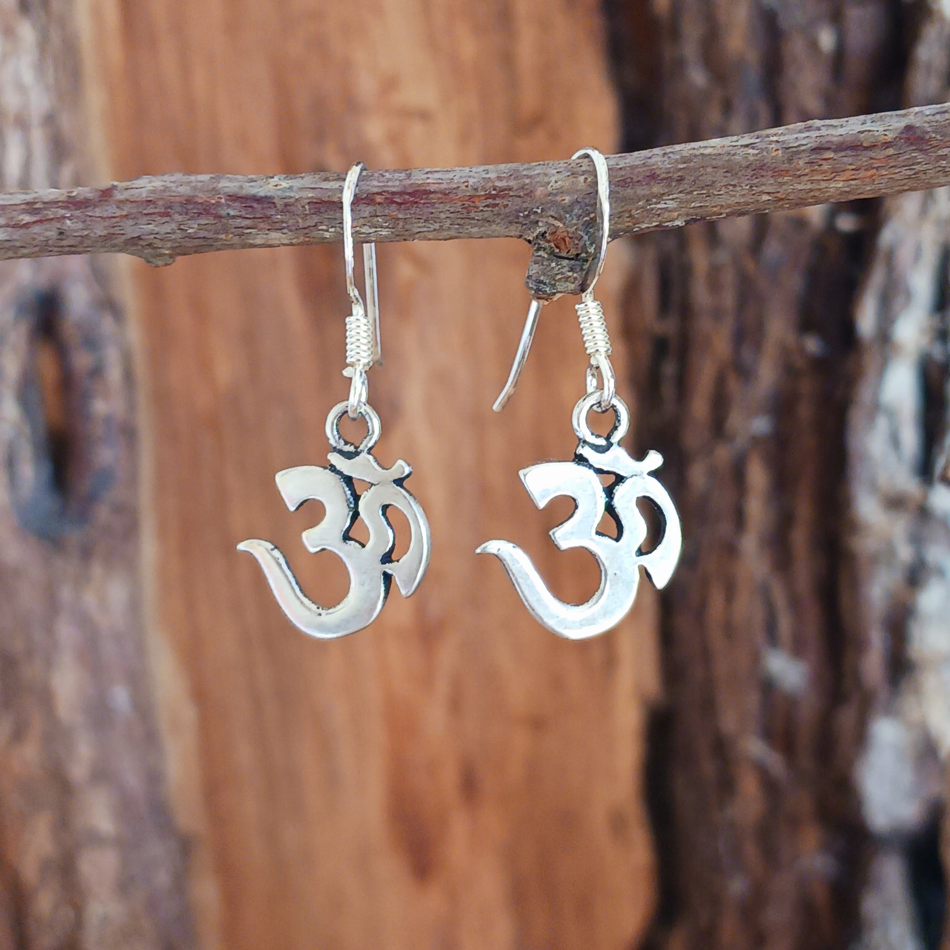 Experience spiritual harmony and elevate your style with these Sterling Silver Om dangle earrings. 