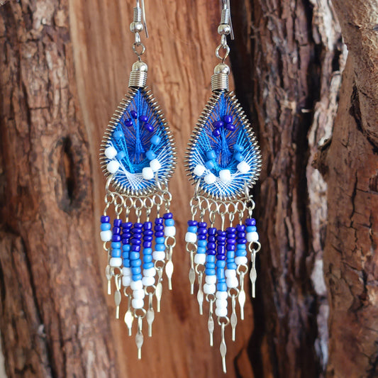 Add a splash of colour to your look with these beautiful handmade Peruvian woven teardrop earrings. Inspired by the vibrant colours and patterns of a peacock feather, each earring features intricate woven detailing complemented by coordinating beads and delicate silver-tone embellishments.