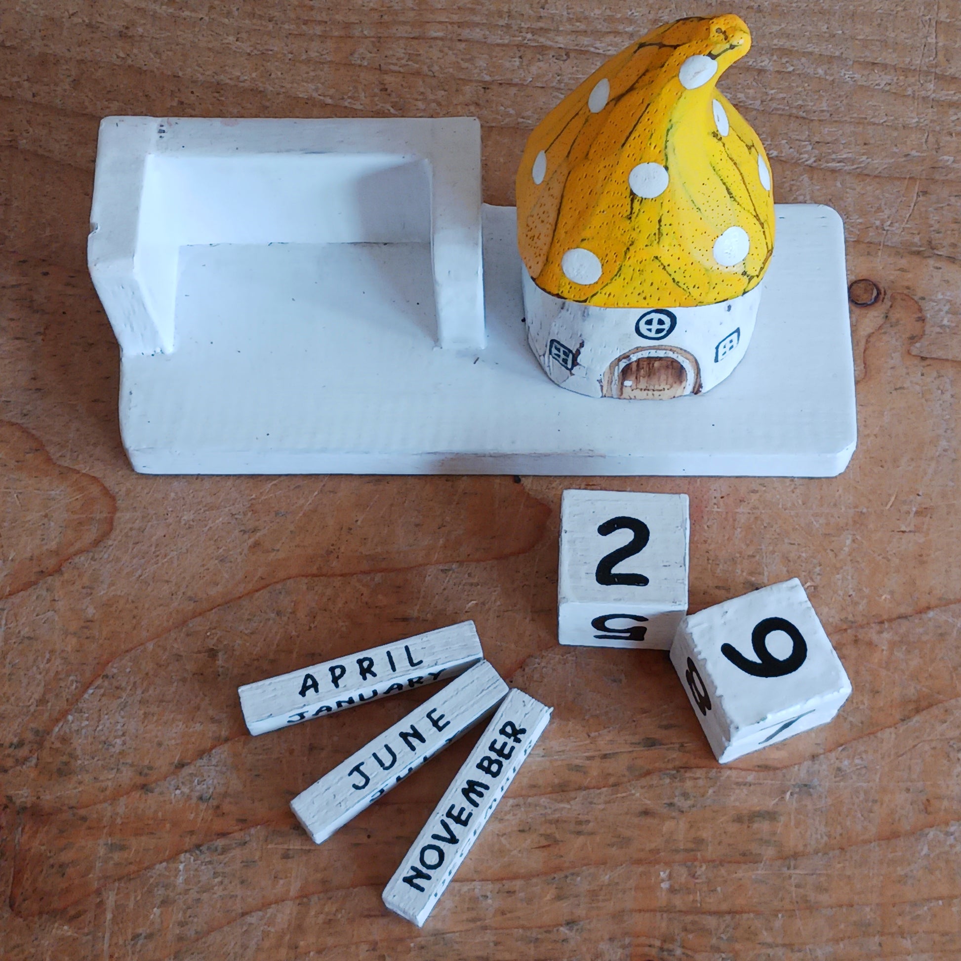 Bring a sprinkle of magic to your everyday routine with the Mushroom House Wooden Calendar. Crafted from lightweight, durable wood, this enchanting piece combines functionality with fairy-tale charm. Each day, simply rotate the wooden blocks to keep track of the date—no need for replacements, making it a timeless addition to your home or office.