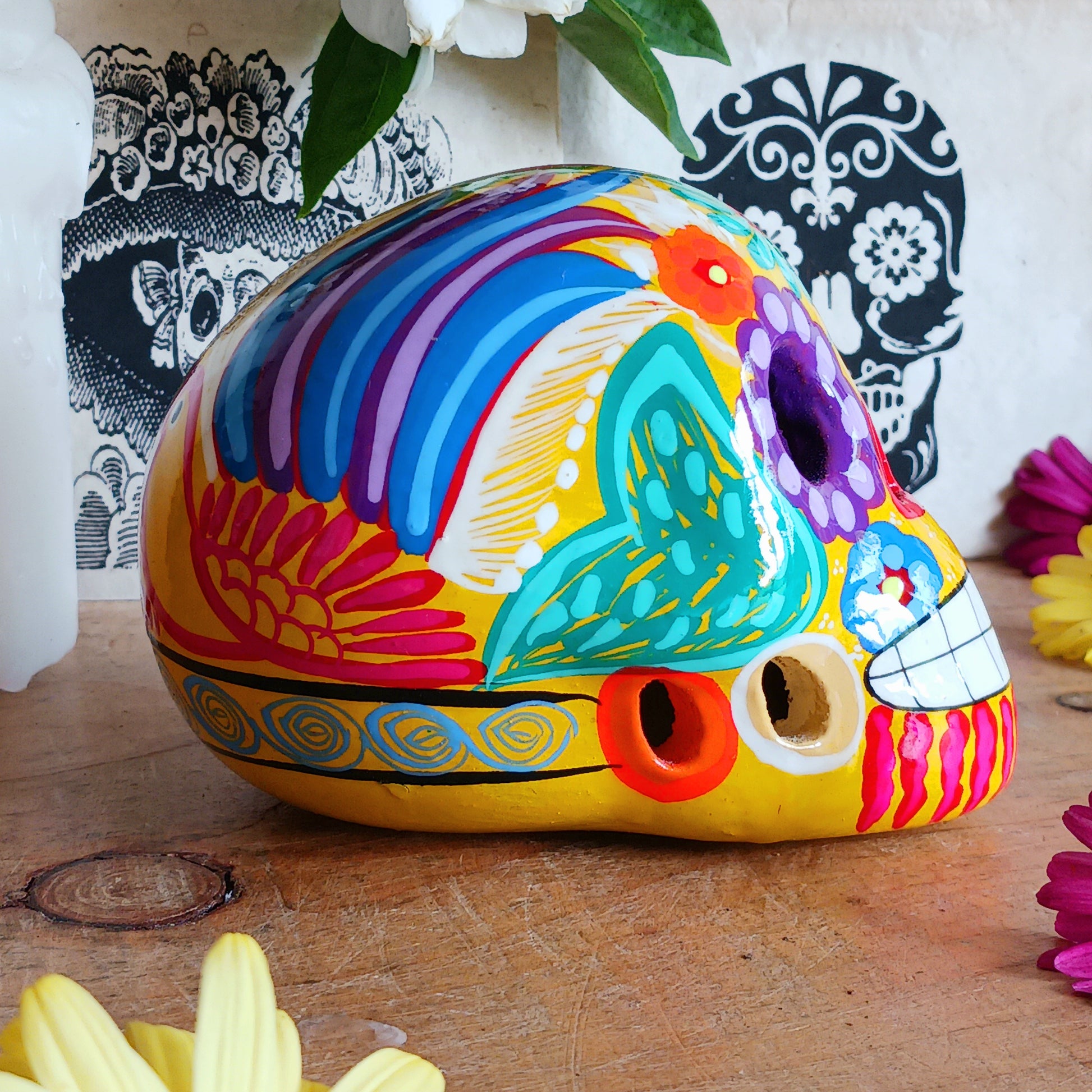 These fun ceramic sugar skull ornaments have been beautifully painted in bright colours and finished with a high shine glaze. They are a popular item during Día de Los Muertos or Day of the Dead festivities, held in Mexico every November to celebrate welcoming the souls of their deceased relatives back for a time of food, drink and celebration.