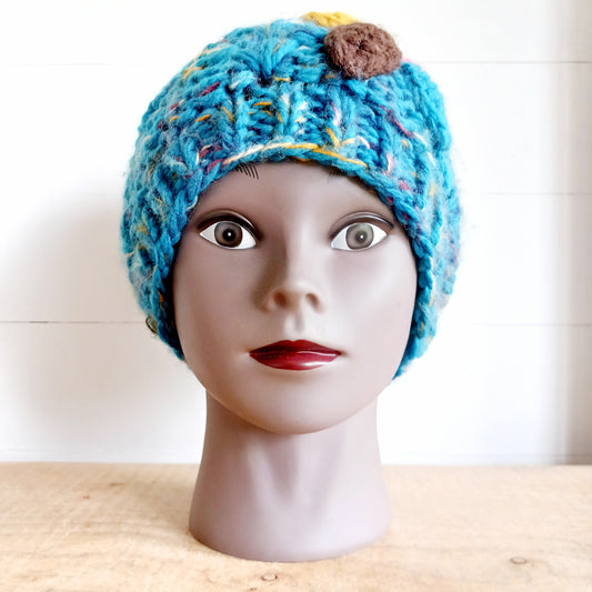 Stay warm in style with this charming knitted wool flower bobble hat, designed to bring both comfort and personality to your winter wardrobe. Crafted from soft, insulating wool, this cozy beanie keeps you snug even on the coldest days.