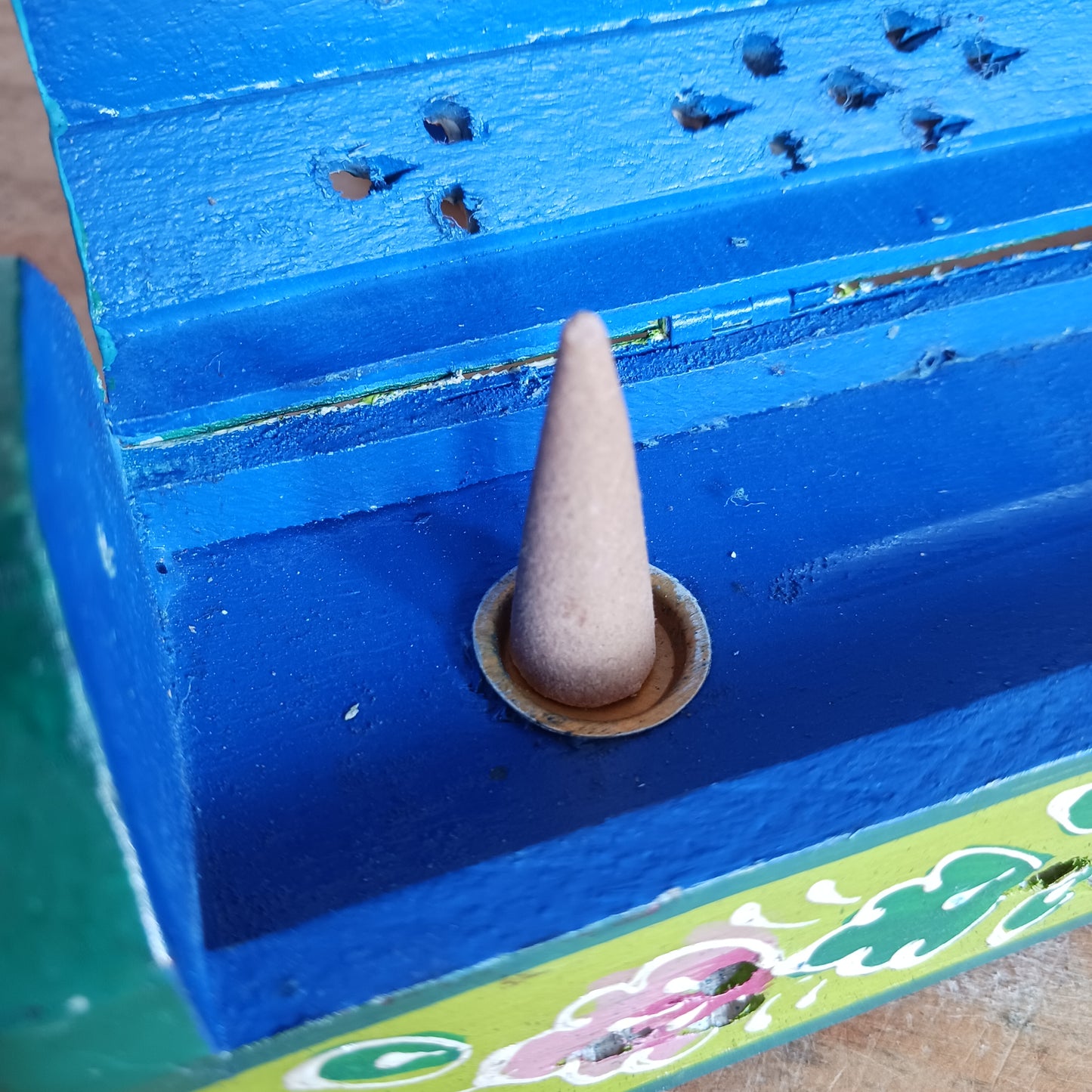 This beautiful pink and green wooden Incense box has been hand painted and has a curved hinged lid. It can accommodate both incense sticks and cones. There is also a place for you to safely store your incense sticks at the bottom on the box.