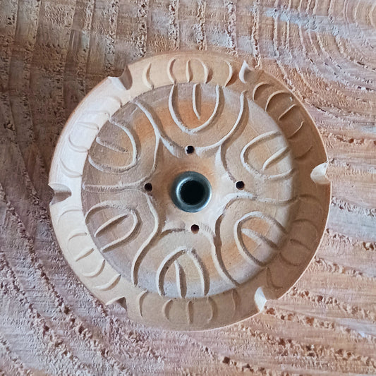 Decorative stone disc with intricate patterns on a textured surface