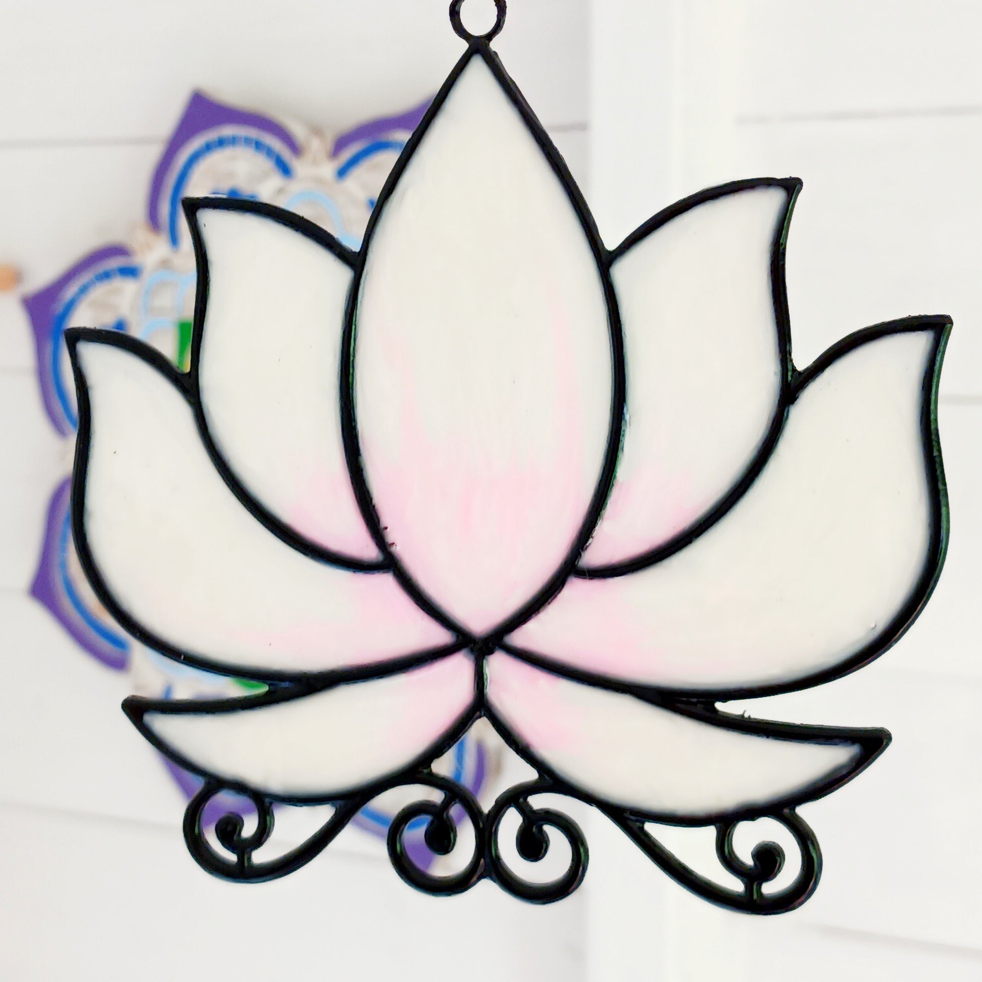 Bring a touch of tranquility to your space with this beautifully crafted lotus flower window hanger. Made from coloured glass and outlined in sleek metal framing, this piece combines simplicity and elegance. When sunlight passes through, it creates a radiant, uplifting display of colour. Hang it in any window to inspire peace, mindfulness, and beauty in your home or workspace.