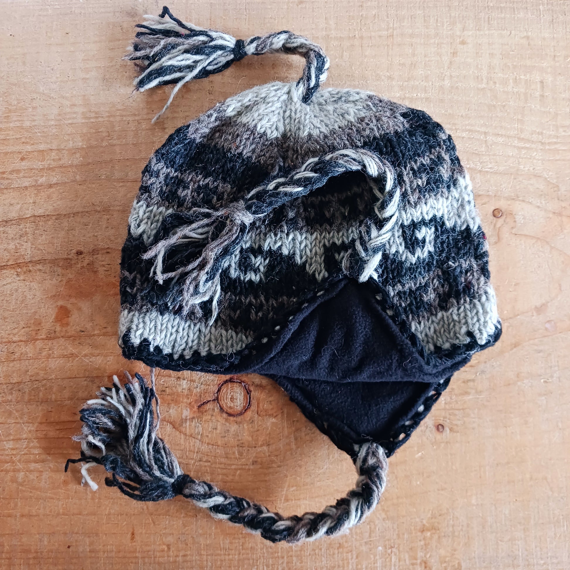 Stay cozy and stylish with our handmade chunky wool earflap hats, crafted in Nepal by skilled women artisans in Kathmandu. Each hat is 100% pure wool and features a soft polar fleece lining for extra warmth and comfort. Perfect for cold winter days, outdoor adventures, or adding a touch of handmade charm to your look.