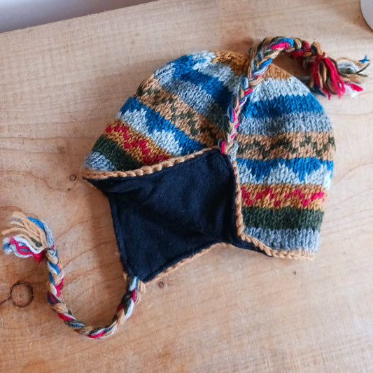 Stay cozy and stylish with our handmade chunky wool earflap hats, crafted in Nepal by skilled women artisans in Kathmandu. Each hat is 100% pure wool and features a soft polar fleece lining for extra warmth and comfort. Perfect for cold winter days, outdoor adventures, or adding a touch of handmade charm to your look.