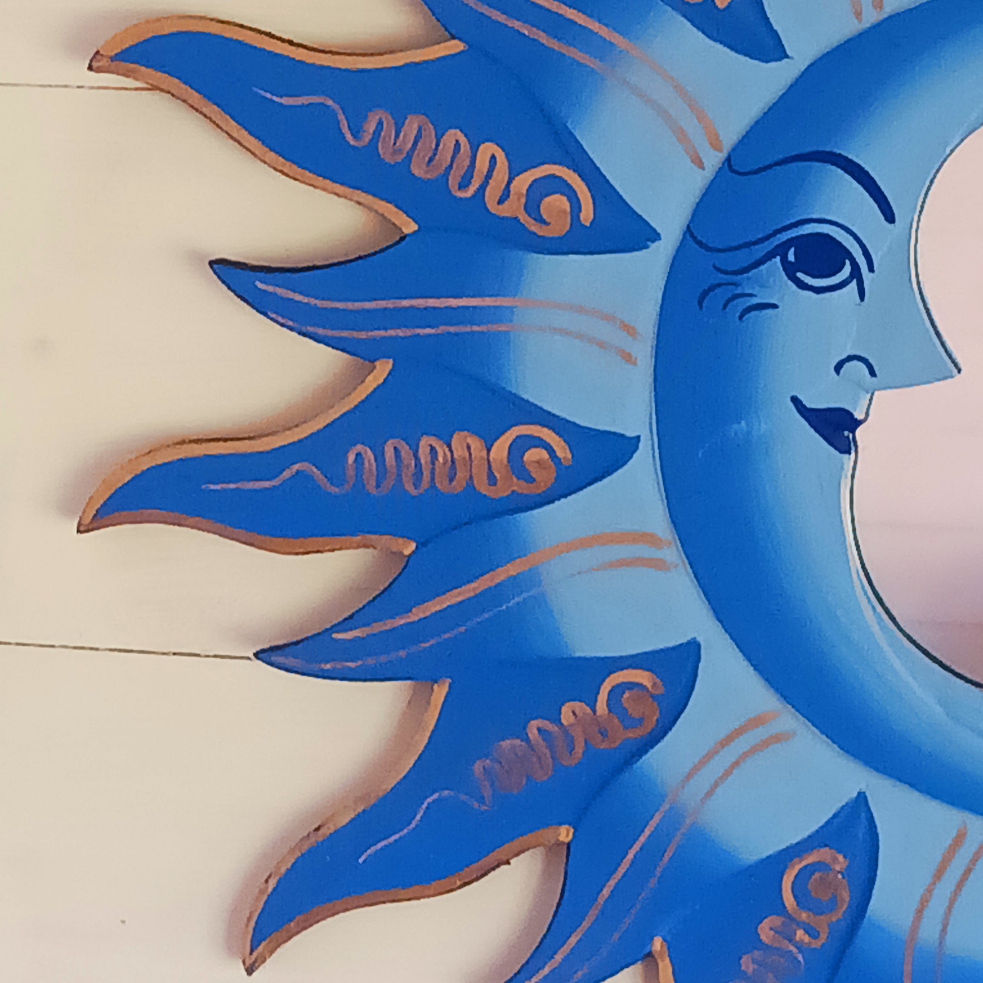 Elevate your home with the mystical charm of our Sun &amp; Moon Mirror. Lovingly handmade by fairtrade artisans, this unique piece features a beautifully painted sun and moon design in vibrant blue tones. Perfect for adding a touch of spirituality, harmony, and positive energy to your living space, this mirror doubles as both a functional piece and captivating art. Ideal for bedrooms, meditation spaces, or as a thoughtful gift for someone special.