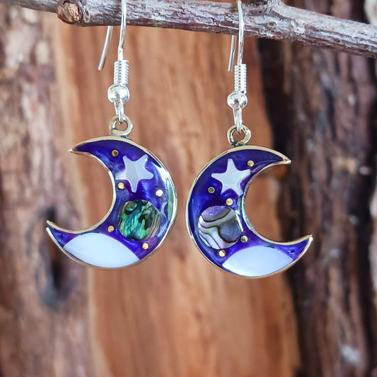 This set of beautiful celestial themed earrings are hand crafted in Taxco, Mexico. Utilising a eye-catching crescent moon design created using traditional Alpaca steel as the frame. These earrings have a celestial theme created using dyed, iridescent abalone shell.