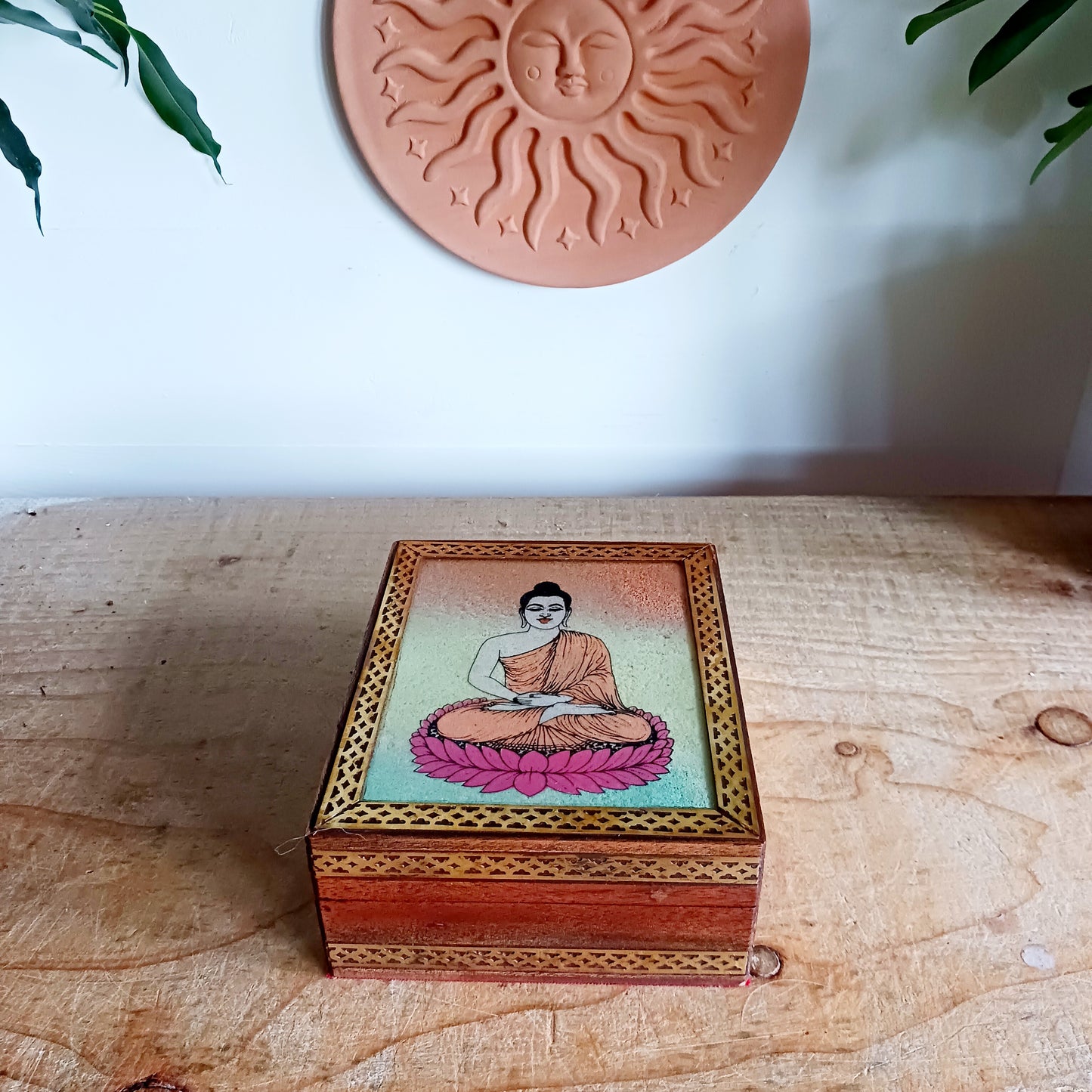 Bring peace and elegance to your space with this exquisite decorative mango wood box. Featuring a vibrant sand painting of Buddha in the meditation mudra, this piece is a true work of art. The detailed image is first hand-painted on a glass top and then filled with colourful sand, giving it depth and texture.