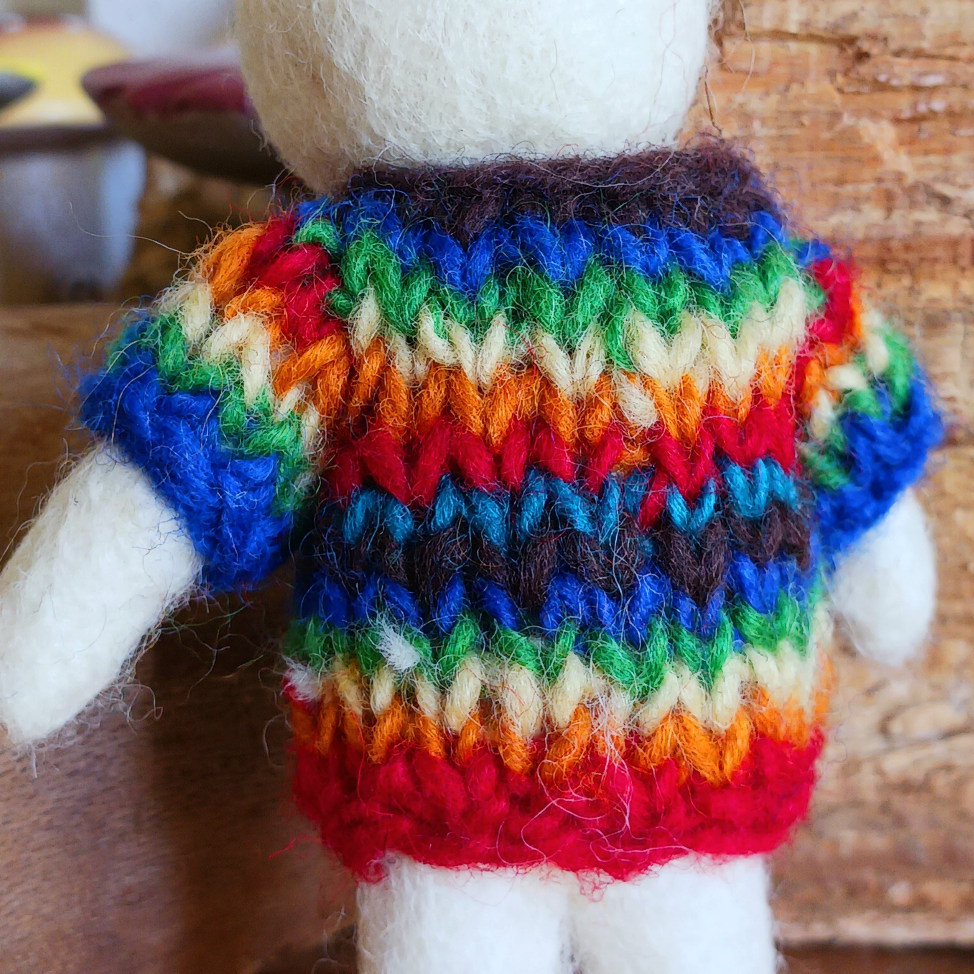 Bring instant festive cheer to your home with this adorable Christmas Tree Mouse Decoration. Dressed in a hand-knitted rainbow jumper and matching hat, this charming little mouse captures the magic of the season at first sight. Its sweet pink nose, expressive eyes, and cartoon-like ears bring out the childlike joy in anyone who sees it.