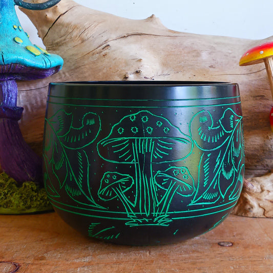 Bring a mystical and nature-inspired touch to your spiritual space with this beautifully crafted Black Aluminium Mushroom Singing Bowl. Handmade in India, this unique cauldron-style singing bowl features a striking black finish decorated with vivid green mushroom artwork, creating an eye-catching piece perfect for meditation rooms, altars, yoga studios, and bohemian interiors.
