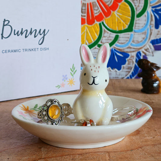 Add a charming touch of spring to your space with this Bunny Floral Ceramic Trinket Dish. Featuring a delicate floral design and a sweet bunny illustration at the center, this dish is perfect for holding jewellery, keys, coins, or other small treasures. Whether placed on a dresser, vanity, or bedside table, it combines functionality with fun and festive decor, making it an ideal gift or seasonal accent.