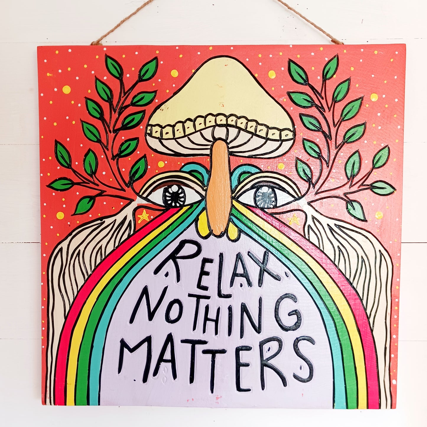 Add a splash of colour and carefree charm to your space with this Relax Nothing Matters Wall Plaque. Handmade by skilled artisans in Indonesia, this standout piece features a vibrant rainbow and whimsical mushroom in an abstract design.