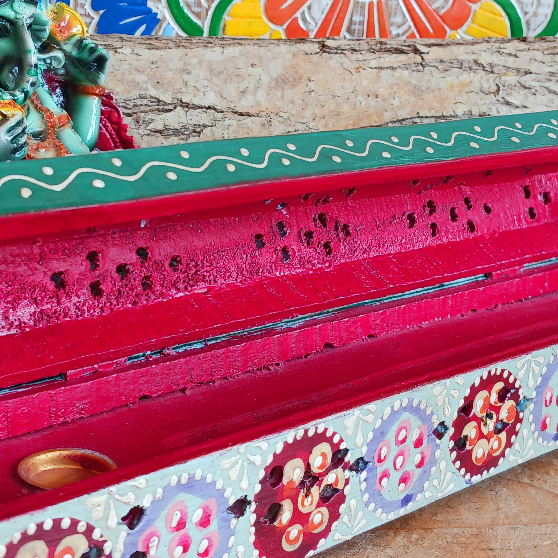 This beautiful turquoise wooden Incense box has been hand painted and has a curved hinged lid. It can accommodate both incense sticks and cones. There is also a place for you to safely store your incense sticks at the bottom on the box.