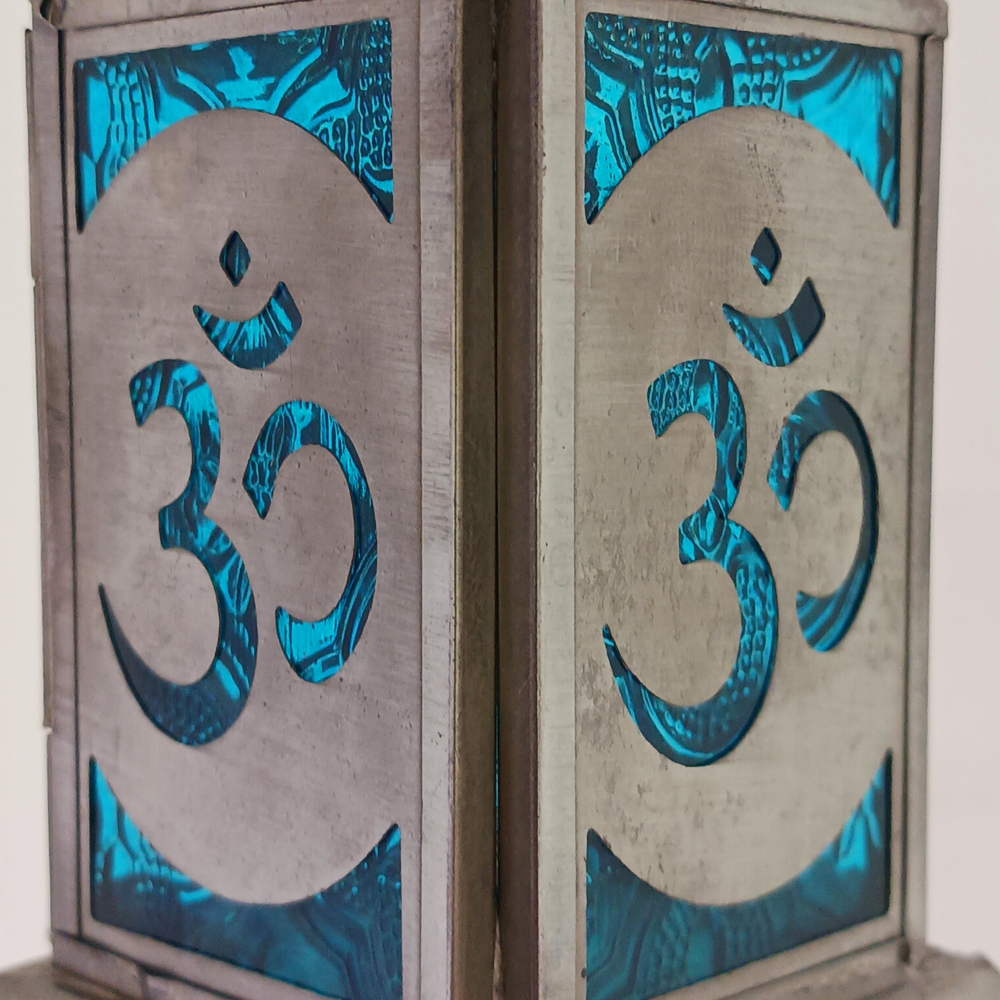 Bring warmth, colour and spiritual harmony to your home with this beautiful Om Symbol Glass Lantern. Designed with vibrant coloured glass panels and a decorative metal cut-out canopy, this lantern creates a calming glow that enhances meditation spaces, yoga rooms and home décor.