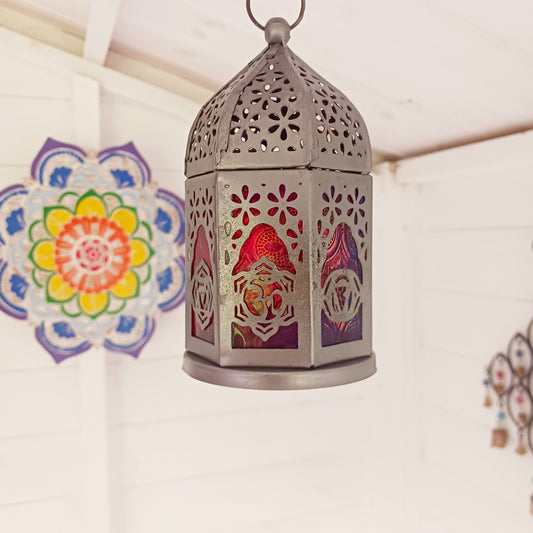 This delightful little seven-sided standing lantern has each side elegantly showcasing a chakra symbol. With a convenient bottom-opening door that doubles as a candle holder tray, this lantern is practical and attractive.