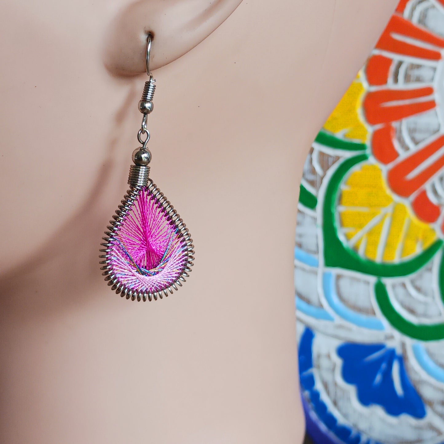 Add a touch of effortless boho elegance to your look with these beautifully handmade woven teardrop earrings. Inspired by the graceful shape of peacock feathers, these lightweight dangly earrings are expertly crafted by skilled artisans in Peru using traditional weaving techniques and vibrant contemporary detailing.