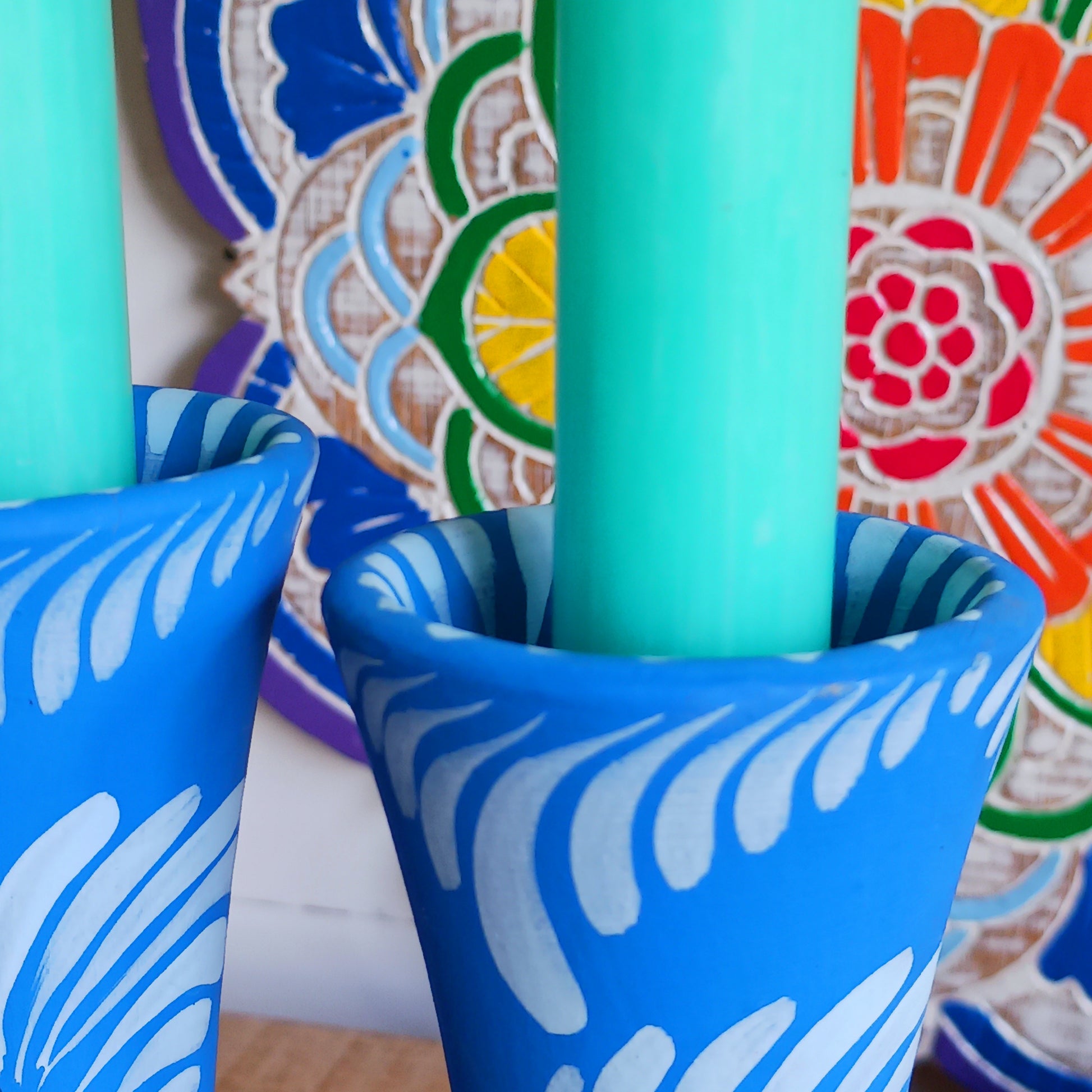 Hand painted in a vibrant blue hue and adorned with the Shapla (waterlily) flower — the national flower of Bangladesh, this fair trade candle holder is a true statement piece. Display it prominently or gift it to someone special as a unique, ethical, and meaningful present. Beautiful on its own or paired with others, it adds warmth, tradition, and cheerful design to any space.