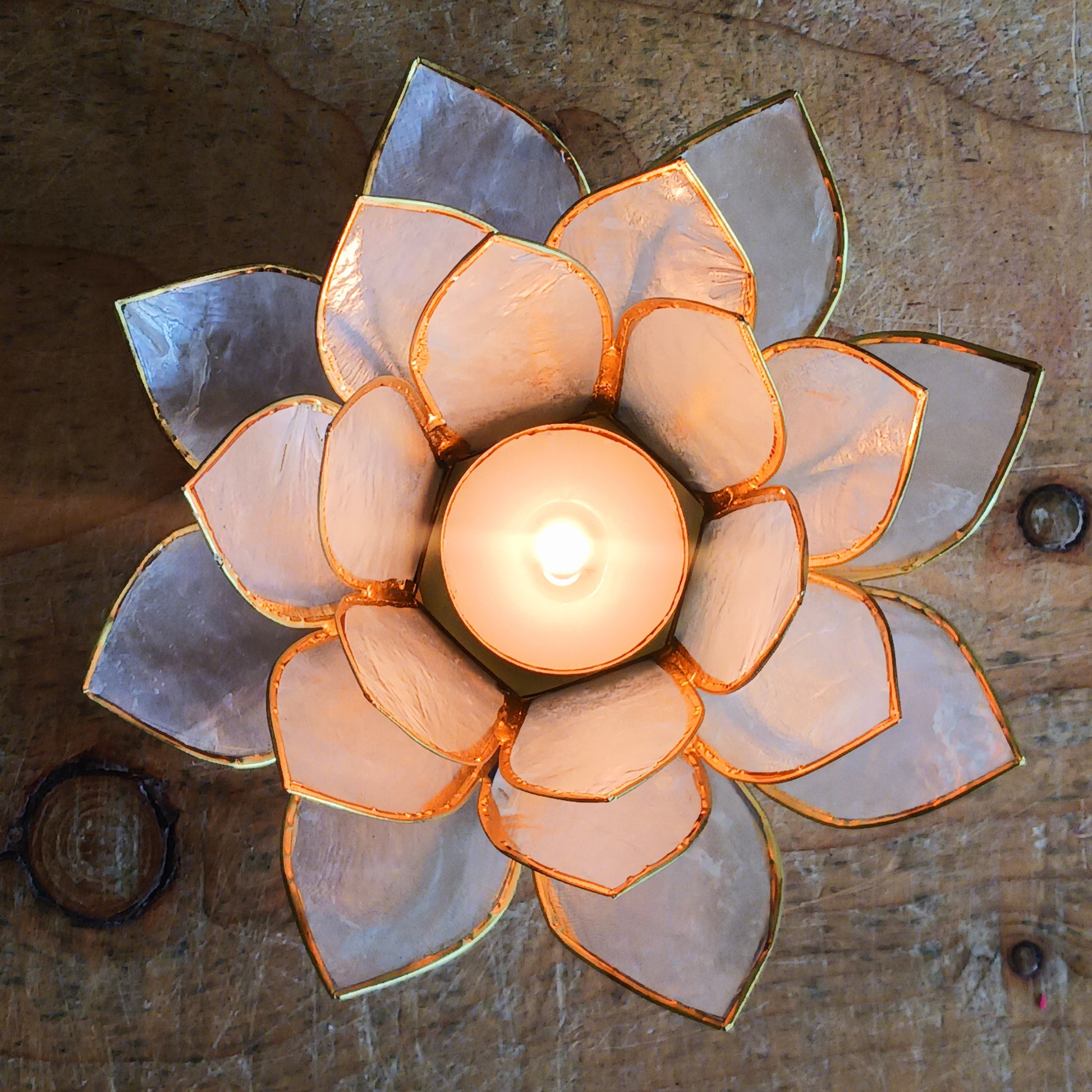 Elegant lotus candle holder made from Capiz shells. Fits 5.5cm candles. Fairtrade, handcrafted, perfect for peaceful indoor & outdoor ambiance.