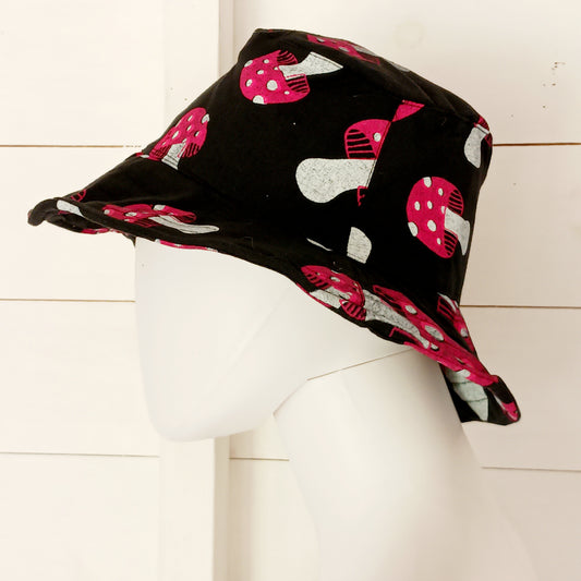 Stand out from the crowd with this lightweight Festival Mushroom Print Bucket Hat. Designed for festival season, holidays, beach days, and everyday summer wear, this stylish bucket hat features a bold all-over mushroom print that adds a fun, eye-catching touch to any outfit.
