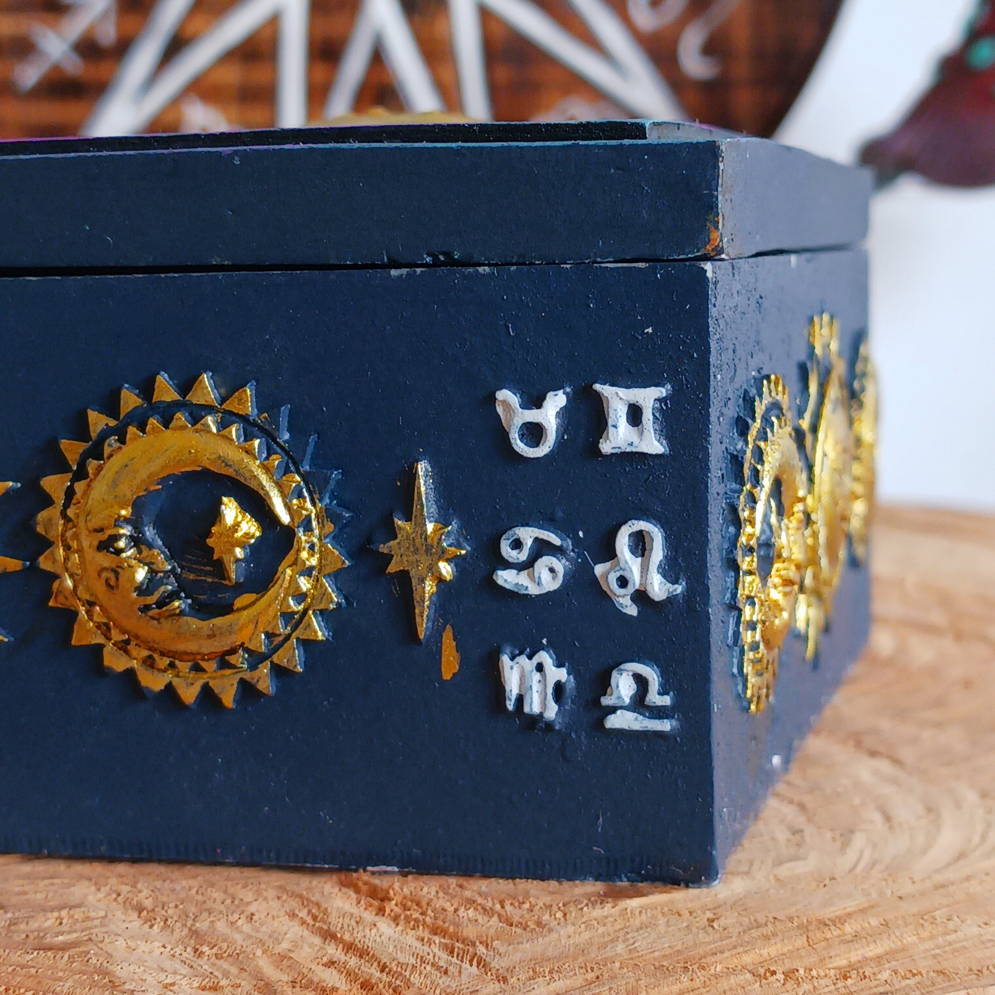 This unusual decorated resin box has raised astrology symbols and a detailed sun and moon design with a gold finish. 
 This celestial style is perfect for holding trinkets, crystals and other small objects for safe keeping.