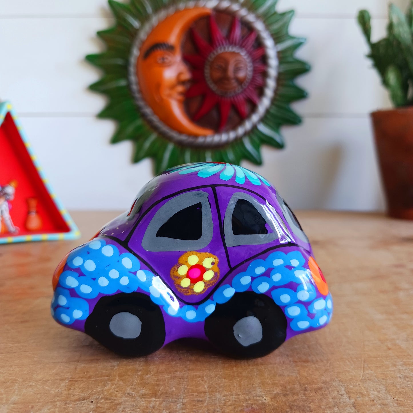 This fun little VW car ornament oozes retro vibes. With it's bold flower power design and vibrant colours it will brighten up any sideboard. This type of car, affectionately known as a 'bochito', are very popular in Mexico due to their reliability when driving about steep roads. Incidentally, the Mexican town of Puebla was home to the last Beetle production factory which only closed in 2003.