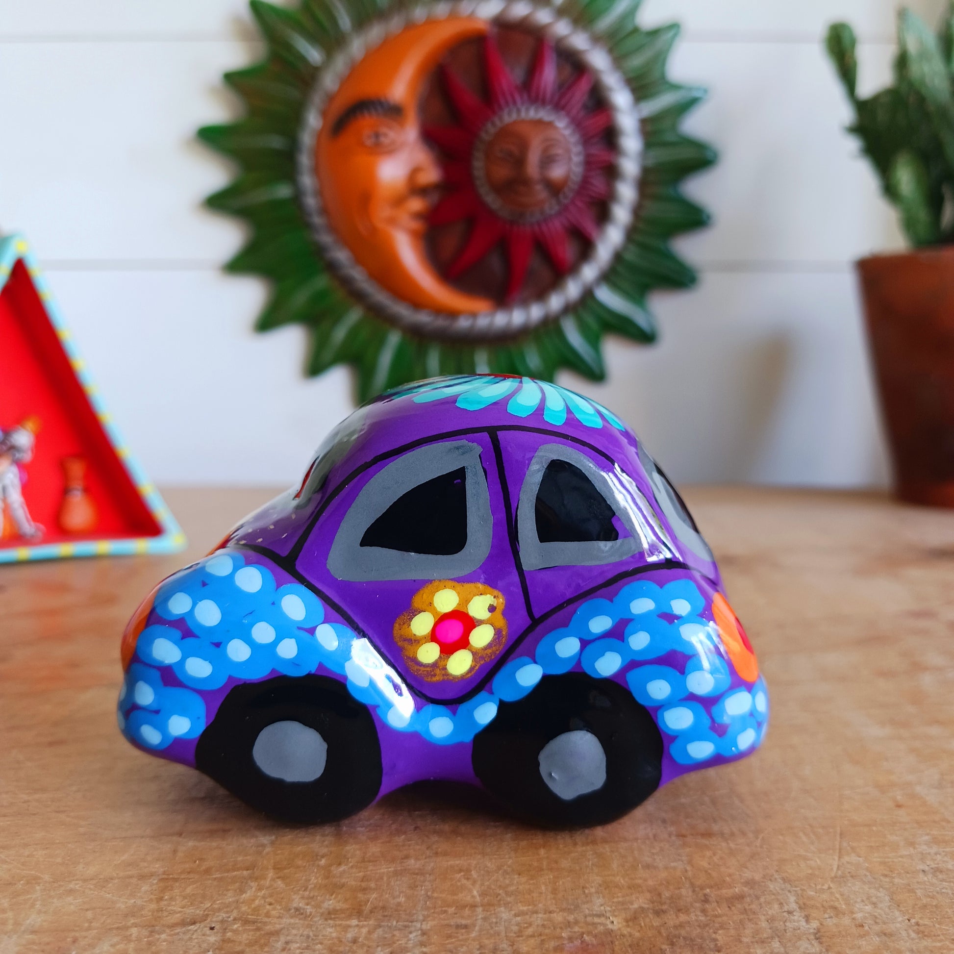 This fun little VW car ornament oozes retro vibes. With it's bold flower power design and vibrant colours it will brighten up any sideboard. This type of car, affectionately known as a 'bochito', are very popular in Mexico due to their reliability when driving about steep roads. Incidentally, the Mexican town of Puebla was home to the last Beetle production factory which only closed in 2003.