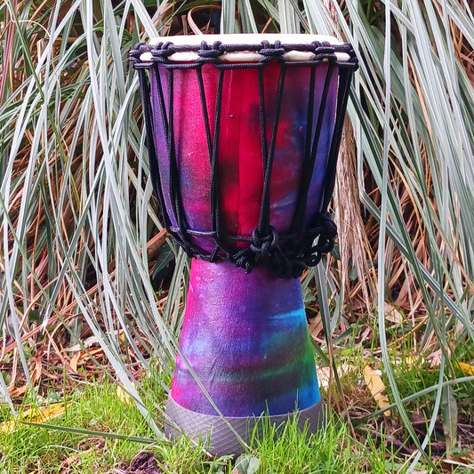 Awaken your rhythm with this handcrafted Rainbow Wooden Djembe from the heart of Indonesia. Standing 30cm tall with a 6–8" head, this compact drum carries the earth’s natural resonance and the spirit of Balinese ceremony. Wrapped in vibrant rainbow sarong fabric and finished with a protective varnish, it radiates healing colour and joyful energy.