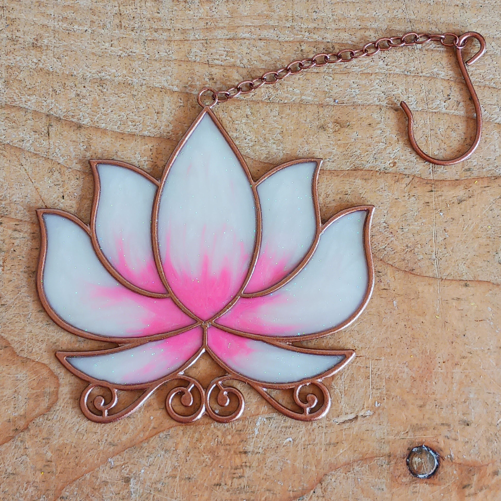 Bring a touch of tranquility to your space with this beautifully crafted lotus flower window hanger. Made from vibrant coloured glass and outlined in sleek metal framing, this piece combines simplicity and elegance. When sunlight passes through, it creates a radiant, uplifting display of color. Hang it in any window to inspire peace, mindfulness, and beauty in your home or workspace.