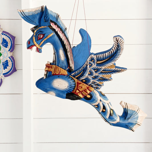 Bring a touch of fantasy to your home with this beautifully handcrafted winged seahorse hanging mobile. Hand-painted in vivid cobalt blue, this enchanting wooden seahorse features intricate painted scales, feather-like detailing and traditional Balinese-inspired decoration.