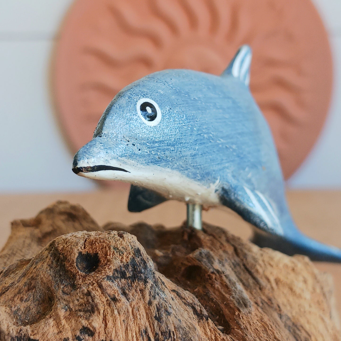 Bring the peaceful beauty of the ocean into your home with this Handcrafted Wooden Blue Dolphin Sculpture. Expertly crafted from sustainably sourced wood, this elegant decorative piece features a beautifully hand-painted blue dolphin gracefully mounted on natural driftwood, creating a striking coastal-inspired display.