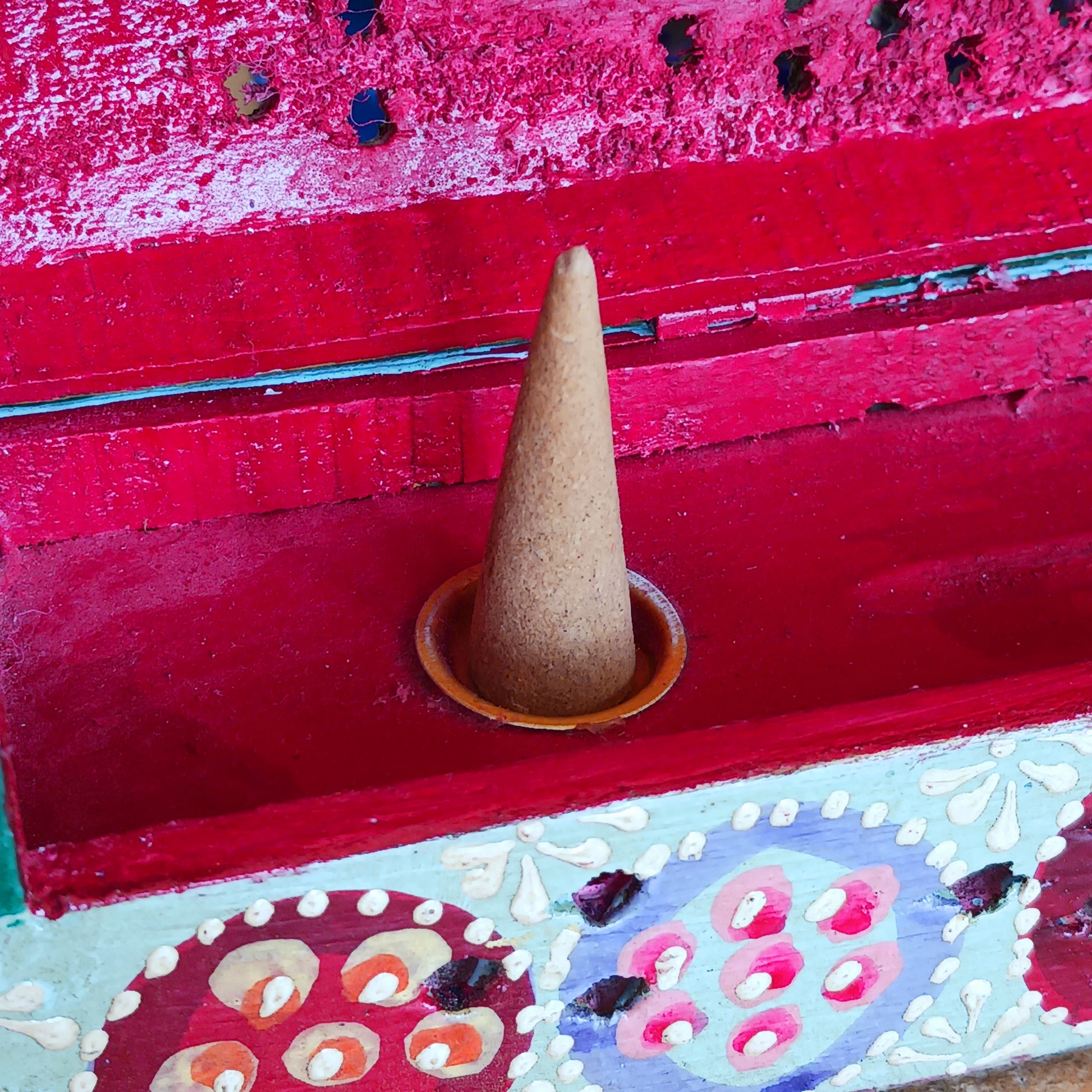 This beautiful turquoise wooden Incense box has been hand painted and has a curved hinged lid. It can accommodate both incense sticks and cones. There is also a place for you to safely store your incense sticks at the bottom on the box.