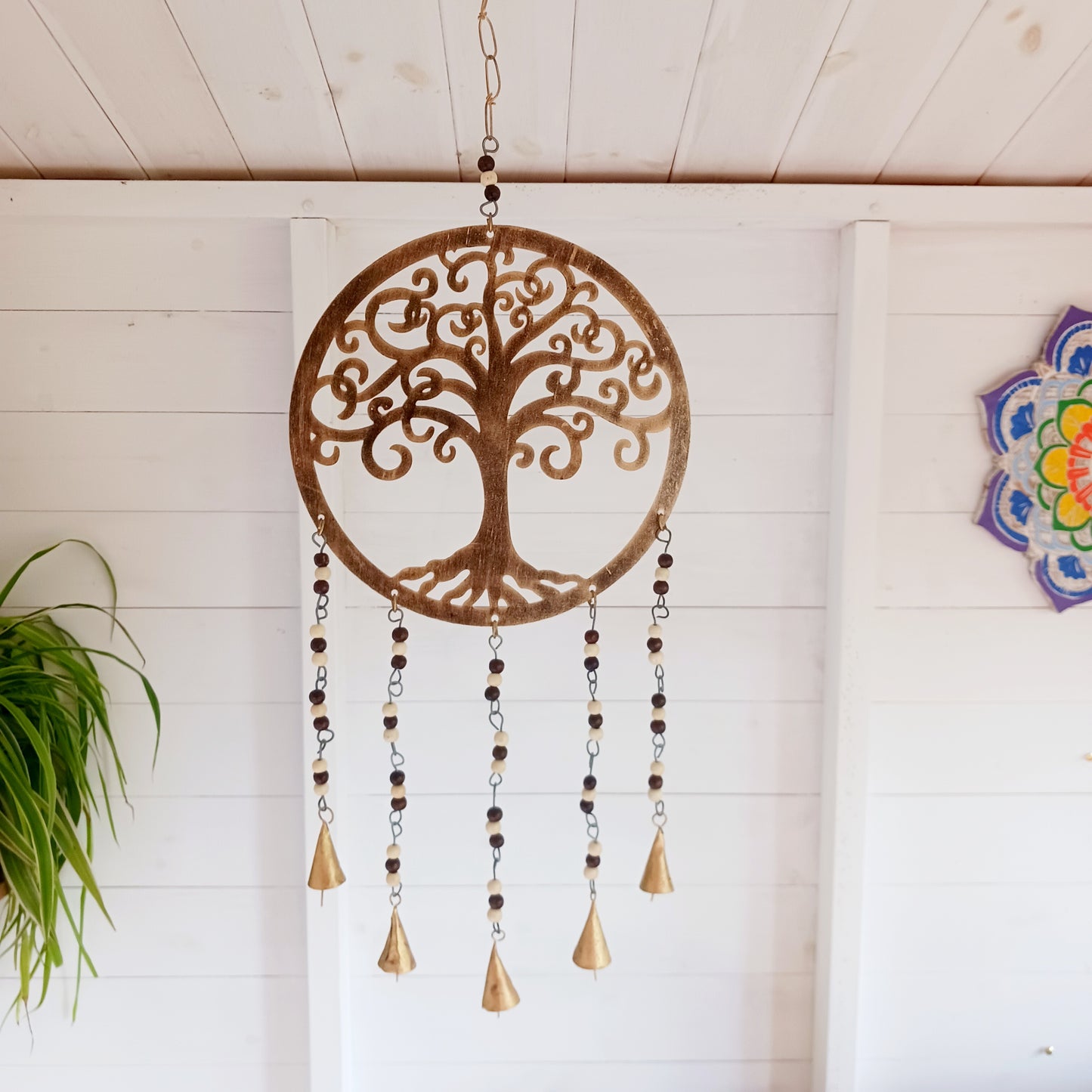 Bring the timeless symbolism of the Tree of Life to your home with this beautiful Tree of Life windchime.  Made in India from quality brass, this 25 cm chime features a beautifully detailed Tree of Life design, adorned with Indian beads. Each branch of the tree is a reminder of growth, connection, and harmony, while the soothing sounds of the bells offer peace to any space.