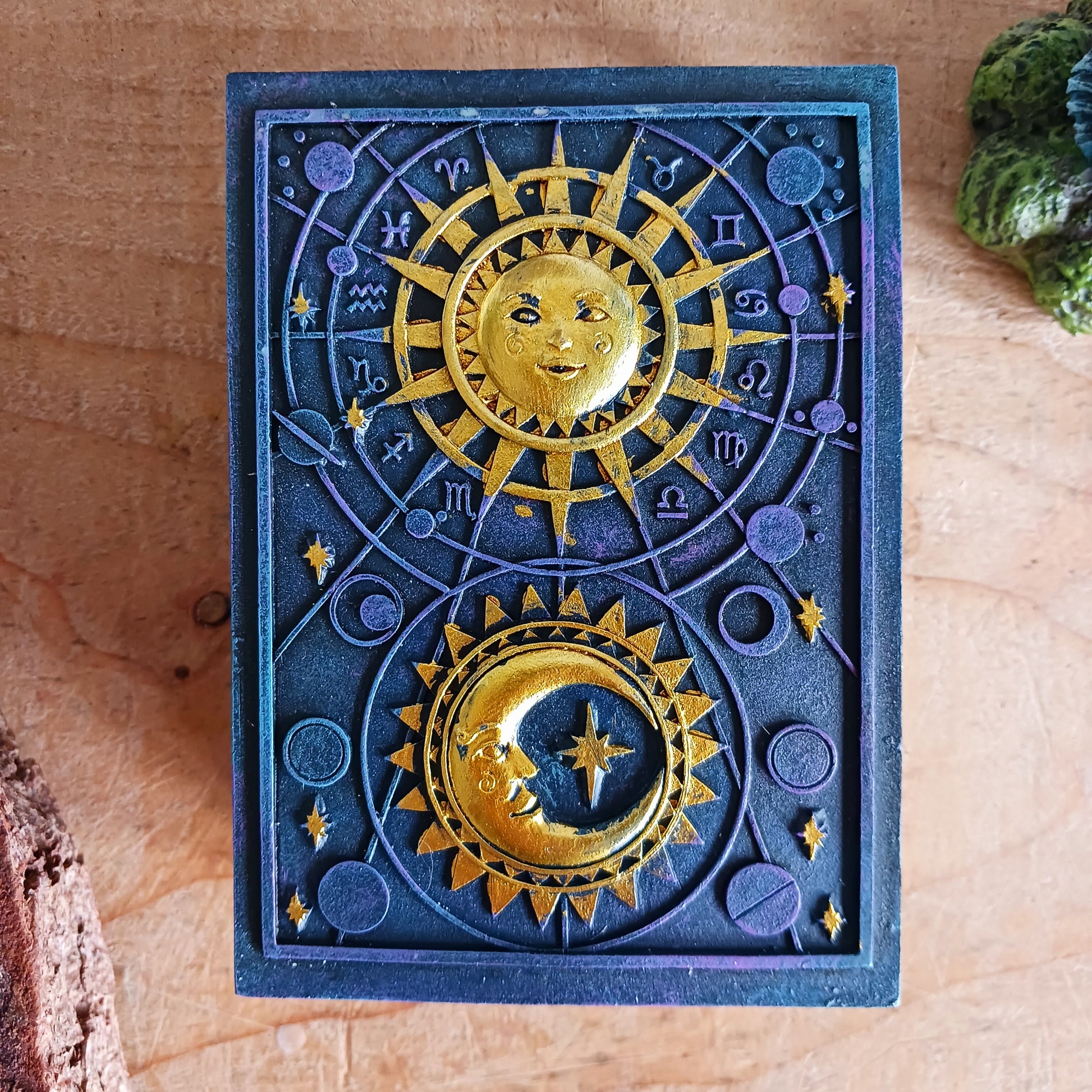 This unusual decorated resin box has raised astrology symbols and a detailed sun and moon design with a gold finish. 
 This celestial style is perfect for holding trinkets, crystals and other small objects for safe keeping.