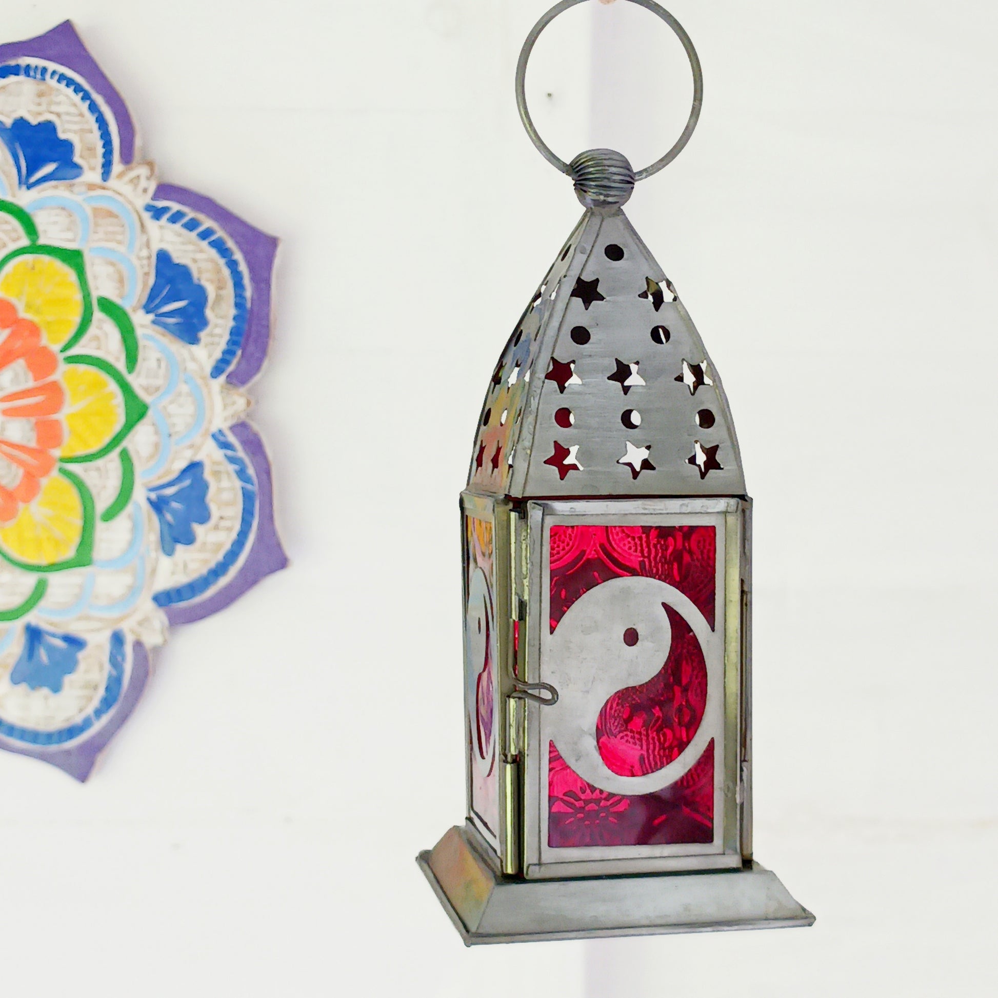 Bring warmth, colour and spiritual harmony to your home with this beautiful Yin Yang Glass Lantern. Designed with vibrant coloured glass panels and a decorative metal cut-out canopy, this lantern creates a calming glow that enhances meditation spaces, yoga rooms and home décor.