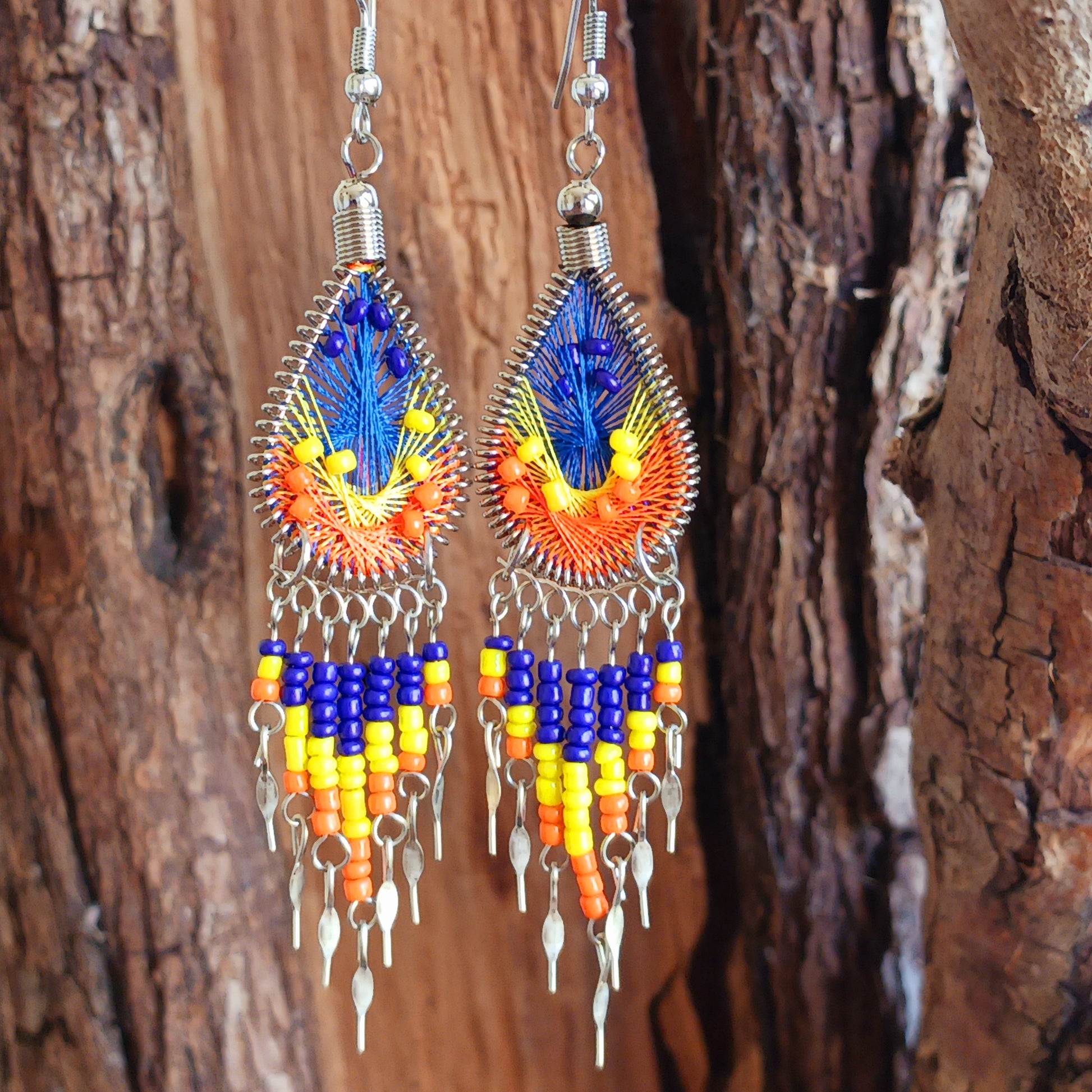 Add a splash of colour to your look with these beautiful handmade Peruvian woven teardrop earrings. Inspired by the vibrant colours and patterns of a peacock feather, each earring features intricate woven detailing complemented by coordinating beads and delicate silver-tone embellishments.