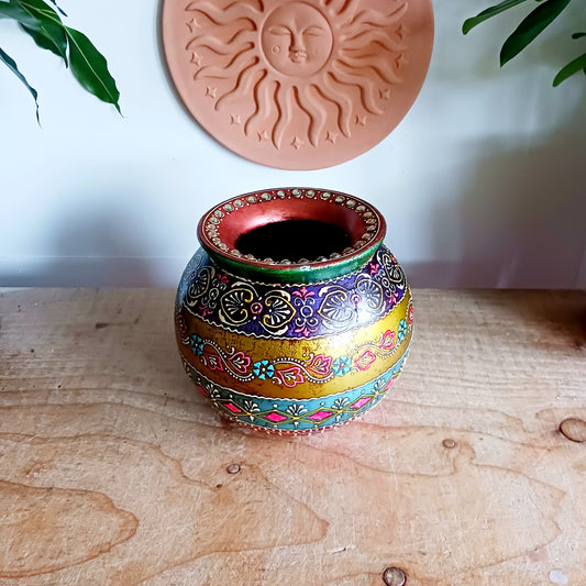 Add timeless character to your home with this beautifully crafted vintage-style wooden decorative pot. Featuring an intricate hand-painted design in rich, warm tones, this ornamental piece is elevated with a delicate gem embellishment that adds texture and visual interest.