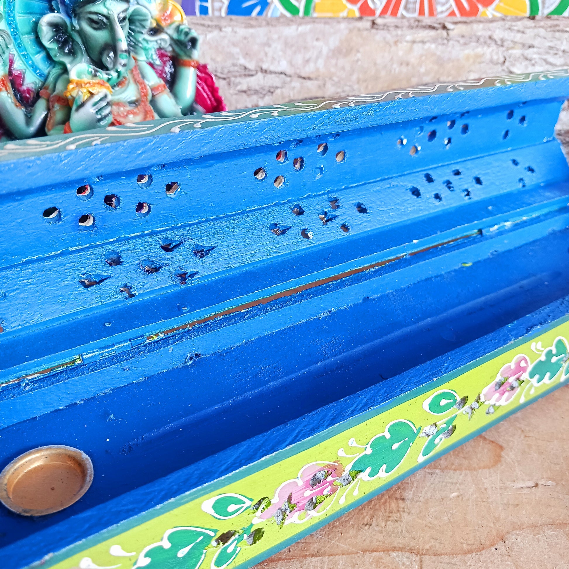 This beautiful pink and green wooden Incense box has been hand painted and has a curved hinged lid. It can accommodate both incense sticks and cones. There is also a place for you to safely store your incense sticks at the bottom on the box.